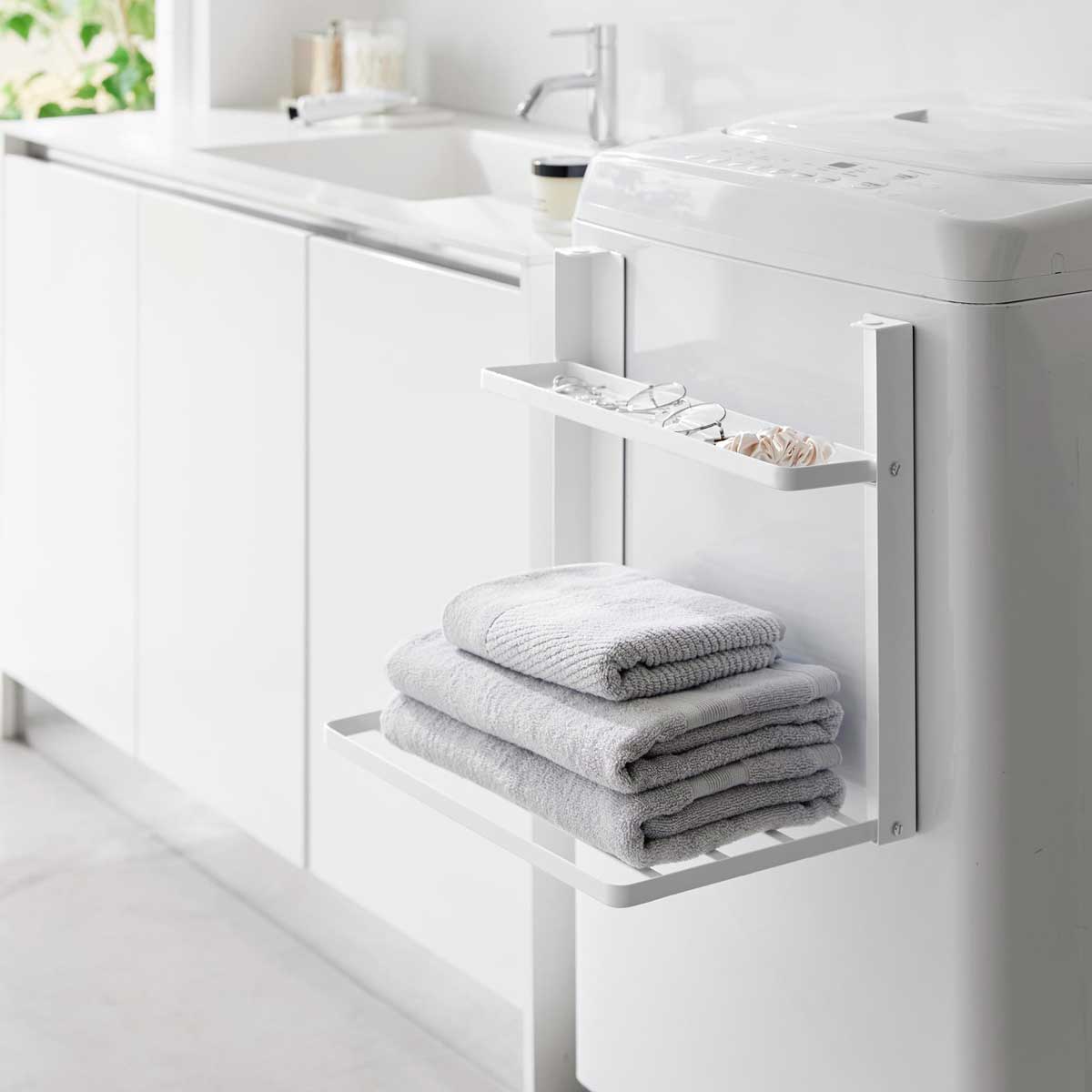 使わない時は2段とも折りたたみ！ タオルや小物の一時置きに便利な折り畳み式の2段棚です。曲面にも取り付けられる構造になっているので、洗濯機の正面、側面のどちらでも取り付け可能です。 収納時は奥行き4cmのスリム設計！ マグネットで洗濯機の正面や側面に簡単に取り付けられます。棚にはお風呂上がりの着替えやバスタオルを、トレーにはメガネやアクセサリー等の小物が収納できます。 商品の情報 ・ブランド：YAMAZAKI（山崎実業）/日本 ・ジャンル：マグネット折り畳み棚 ・主な素材：スチール 粉体塗装、マグネット（本体）/シリコーン（滑り止め、クッション） ・サイズ：約W410xD260xH365mm（使用時）/約W410xD40xH365mm（収納時） ・内寸サイズ：約W395xD87mm（トレー）/約W395xD230mm（棚） ・重量：約2000g ・耐荷重：トレー1kg/棚1.5kg ・使用できる面：マグネットがつく面 スチール面 この商品の仲間たち tower タワー 洗濯機横マグネット折り畳み棚 2段 1717 ホワイト tower タワー 洗濯機横マグネット折り畳み棚 2段 1718 ブラック