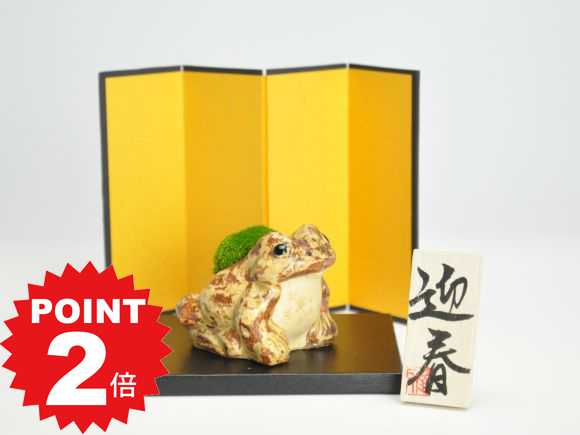 商品詳細 SPEC 幅6cm×奥行6.5cm×高さ6cm 屏風17.5cm×12cm 敷物12cm×9cm×0.7cm 木札6cm×2.7cm *写真は代表的なイメージ写真になります。お届けする盆栽は数量物の為、高さ、枝ぶり、鉢の種類が写真とは異なる場合がございます。 育て方冊子と肥料が付属しますので初心者でも安心です。電話・メールでのサポートもしております。 ラッピングは無料です。ご注文時にお申しつけ下さい。 通常2営業日以内に発送致します。お急ぎの場合はご連絡下さい。土日祝日は発送お休みです。 かえるの苔盆栽迎春セット　【屏風、敷板、木札付き】 ちょっとリアルな苔かえる。すぐに飾れるセットです。 信楽焼のかえる ひとつひとつ丁寧に手作りされました。 背中にこんもり苔を背負っています。 かえるはその名前にちなんで 「帰る」「変える」「返る」など 縁起のいい言いかえをされることがあります。 福がカエル、無事にカエルや、 「むかえる」でお客様を迎える 玄関の置物にもよいとされています。 こちらの商品には屏風、敷板、 迎春の木札が付属しており、 すぐに飾ることができます。 ご自宅用だけでなく 贈り物にも喜ばれるセットです。 春を迎える準備にいかがでしょうか。 数量ものの商品です。 メインの写真は12月頃の姿です。幅6cm×奥行6.5cm×高さ6cm 屏風17.5cm×12cm 敷物12cm×9cm×0.7cm 木札6cm×2.7cm 季節に応じて苔の種類が異なる場合がございます。 かえるの苔盆栽迎春セット　【屏風、敷板、木札付き】の育て方 山苔やギンゴケは半日陰を好みますので、直射日光のあたらない、木漏れ日があたる明るい日陰や室内では2〜5時間光が当たる場所に置き、白っぽく乾燥してきたら水を与えます。土まで染みこむぐらい念入りに霧吹きで水を吹きかけます。かえるの苔盆栽迎春セット　【屏風、敷板、木札付き】 信楽焼のかえるの背中に苔がこんもり。 雨の日には生き生きとした苔を背負った 癒やしのかえるになっちゃいます。 かえるの苔盆栽、敷物、金屏風、木札が付属しています。 コンパクトサイズで飾る場所を選びません。 お正月だけでなく、一年を通して和のインテリアとしてもお楽しみいただけます。 またお祝い事や、開店祝い、出産祝い、ご両親への贈り物にも喜ばれます。 かえる好きの方にもおすすめです。 かわいいかえるを迎えてみてはいかがでしょうか。 ずっとそばにいさせてね。 あなたを見守るつぶらなひとみと緑の苔、ふっくらとしたもふもふの苔はそっとなでたくなるほどの可愛さです。 リビングやキッチン、トイレや窓辺、ちょっとしたスペースにかえる盆栽を置くと微笑まずにはいられません。 毎日笑顔で癒やされたい。 どこにでも置けるサイズです。 お部屋にずっと置いてても育てられる苔盆栽です。 かえる盆栽のサイズは約 幅7cm×奥行7cm×高さ6.5cm。 手のひらサイズなのでどこにでも置くことができます。食卓や勉強机、職場のデスクなどちょっとした場所に飾れます。 苔は乾燥してきたら霧吹きして潤します。乾燥してしまっても大丈夫。水分を与えるとうるおいます。乾燥気味に育てるのがうまく育てるポイントです。水を与えすぎると傷んでしまいます。苔は傷んだら張替えることもできます。 お腹に穴が開いているので 水が抜けて通気性が良いです。 モフモフとした緑のふくらみ 思わず頬ずりしたくなる、やさしい風合いの苔の魅力 ほわほわした緑の葉がぷっくりとした苔。丸っこい愛らしい姿に心癒され笑顔がこぼれます。 苔は、山苔と呼ばれる奥深い山に生える樹の根元に自生する苔です。生い茂る木々の葉からこぼれる光を浴び、空気中の水分や朝露で生きているので乾燥に強く、まったく乾燥した状態では仮死状態になり、水を与えると再生します。水分を与えすぎると蒸れて傷んだりしますので風通しの良い場所で管理するようにしてください。 日本人が生活に緑を取り入れるのに適した盆栽 盆栽は自然の風景を器に模したものになります。緑や花や紅葉といった四季を身近に感じられる良さが観葉植物と違って盆栽にはあります。都会で生活する中で四季を感じづらくなった私たちにぴったり、また盆栽の日々の成長を感じることで毎日が楽しくなり張りがでます。生活に緑をとりいれるなら盆栽をおすすめする理由です。 愛らしいかえるの姿と苔の魅力、盆栽を楽しむきっかけになるとうれしいです。 リビングやデスクにちょこっと置ける気軽なグリーン 見守ってくれるかえるにほっこり ★ラッピングについて★ ラッピングをご希望の場合は、赤系、青系、緑系、いずれかをご選択下さい。 納品書等の金額が分かるものはお入れしておりません。 なお、ご指定が無い場合はプチプチで包装して通常梱包でお送りします。 ★メッセージカードも承ります★ オリジナルメッセージをご希望の場合は、備考欄に60文字以内でご記入下さい。 ☆お届けについて☆ 当店は香川県からの発送のため、東海地方以東は 午前中と12時から14時のご指定ですと 2日かかります。 お届けが2日以上かかる場合がございます。 ご了承の上、ご注文くださいませ。