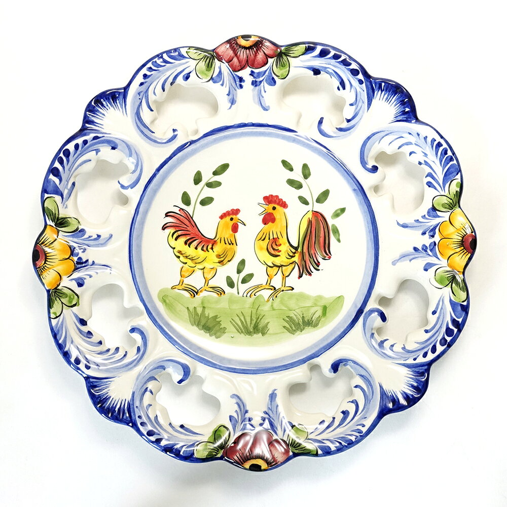 ●ポルトガルのリスボンの北アルコバッサの小さなファクトリーで作った装飾皿（プレート） ●幸せを呼ぶ鳥として有名なバルセロスのニワトリが描かれています ●日本では当店のみの取り扱いとなっております ●透かしの入った凝った形も素敵です ●陶器の模様から、にわとりのペイントまで全てハンドメイドの飾り皿です ●一枚一枚職人が手描きしています。花の形や色、大きさ、数などは写真と同じとは限らず、全てが貴方だけの一点ものとなります ●裏に紐を通す穴が開いています、壁掛けにどうぞ ●ポルトガル土産としてよく知られているGALO DE BARCELOS（バルセロスの雄鶏）はポルトガルでは「神のご加護と幸運」が受けられるお守りとして知られています。このニワトリにはちょっとした伝説が・・・。 ⇒詳しくは『欧州雑貨まめ知識』にて●お皿として、食器としても使用できます ●ヨーロッパ・ポルトガルのお土産として ●貴方の絵皿コレクションにどうぞ ●玄関やキッチン、外壁に飾って下さい ●お宅のお守り代わりに ●レストランや店舗のディスプレイに ●プレゼントに、ギフトに、お祝いに ●酉年の方へのプレゼントに 原産国 ポルトガル製 サイズ 直径約26cm 材質 陶器製 ハンドメイド・ハンドペイント ご注意 全てハンドペイントの為、一点一点全て柄が異なります。写真は代表的な物を掲載していますこの商品はアウトレット商品です 壁掛け用の穴が余計に開いてしまっておりますが、使用上問題ありません。 -アウトレット商品購入時のご注意- ・こちらのコーナーの商品は、ショールーム展示品、キズ物、現品商品、在庫処分品や廃盤品などアウトレット扱いとし、特別価格にて販売しております。 ・輸送中の破損等を除き、アウトレット品の返品・交換はできません。 ・アウトレット品につき、プレゼント包装は致しかねます。 ・ご購入前に気になる箇所があれば、ご質問下さいますようお願いいたします。(TEL:072-965-1911　大阪) ・それぞれの商品がお求めやすい価格の理由等は各ページをご参照下さい。