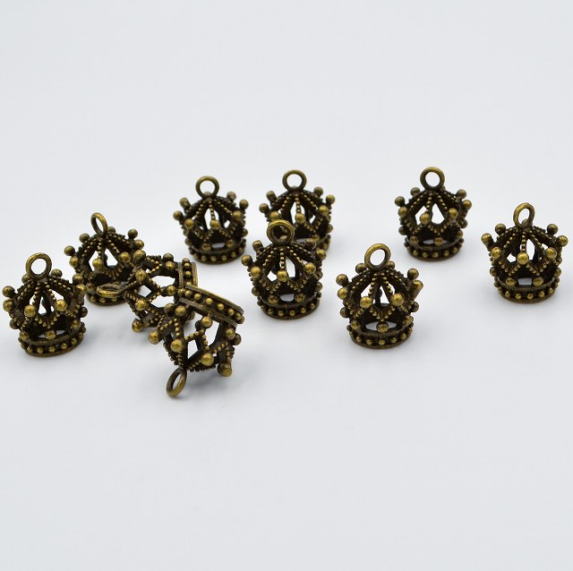 デザイン性のある、王冠チャームです。 メリーゴーランドのような豪華なデザインで、気持ちを高めさせてくれます。 サイズ(概寸)：高さ約10mm×直径約14mm ホールサイズ　約2.5mm 数量：10個 アンティークゴールド 金 金色 ゴールド デザイン 模様 柄 王子 王 王子様 帽子 かんむり 冠 クラウン 王冠リング リング 人形 フィギア ストラップ ペンダント ブレスレット イヤリング デコ DIY ハンドメイド 手作り 贈り物 プレゼントオーナメント 工芸品 パーツ チャームパーツ アクセサリーパーツ ペンダントトップ 部品パーツ 部品 可愛いチャーム メタルチャーム ワンポイント DIYご購入前に必ずご確認ください 同梱と送料について 複数商品を一緒にご購入の場合は同梱発送いたします。送料は1件分のみとなります。他の商品もぜひご検討ください。 製品の製造・品質について 当店の商品は中国の提携工場等で大量生産を行っており、簡易検品を行っておりますが、 製造過程で小さな擦り傷、色ムラ、微細なダメージ等がある商品が混ざる場合がございます。 数量・計量について 一部の商品は重量での計測により、梱包しているものがございます。 数量に若干の誤差が生じる場合がございます。 色味・画像について 商品画像はできるだけ実物に近づけて撮影しておりますが、 光の加減やカメラ、モニター環境により、実物と色合いが異なる場合がございます。 個体差について 入荷時期やロットにより色調や質感に個体差があります。 特に天然素材を用いた商品は模様や色味が一点ずつ異なります。 サイズ表記について 商品のサイズは概寸です。多少の誤差はご了承ください。 安全上のご注意 小さなパーツを含む商品がございます。 小さなお子様の誤飲などには十分ご注意ください。 不具合・トラブルについて 万が一、商品の不具合や梱包ミス等がございましたら、 お手数ですが早めにご連絡ください。迅速に対応いたします。