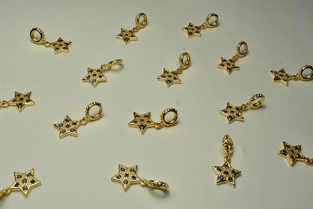 石付を埋め込んだ小さいチャームです。 キラキラしていて綺麗です。ピアス、イヤリングにどうぞ。 サイズ：縦約11.5mm×横約10mm（マルカン含まず）マルカン外径：7mm 数量：2個 金 金色 ゴールド 星 スター 青 青色 ブルー ストラ...