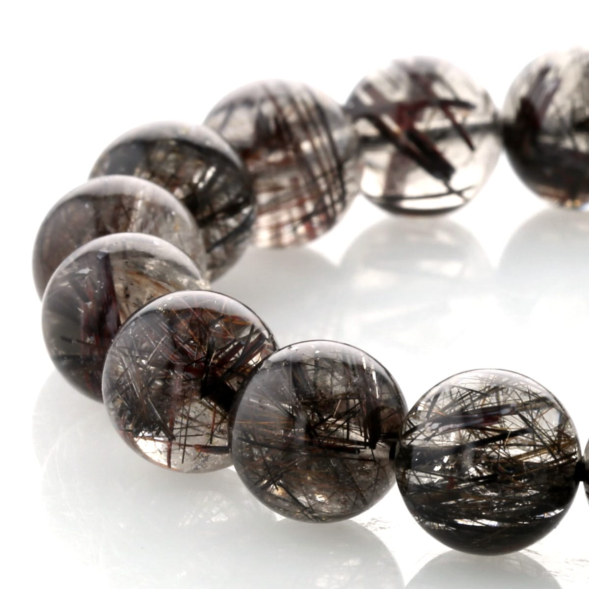 希少な二酸化チタン鉱物「ルチル（金紅石）」を内包した、ブラックルチルクォーツです。 渋くギラっと輝く金属質の黒い針は、力強さと緊張感を感じさせ、水晶の高い透明感と相まって、非常に完成度の高い美しさを備えています。 本品は水晶部分の透明度が特に高く、黒針の入り方・量・太さのバランスが非常に良好な一点です。 全体の調和が取れており、見た目・品質ともに優れていることから、プレミアムクラスとしてご紹介いたします。 ブラックルチルは、決断力・行動力・集中力を高める石とされ、 勝負事やビジネスシーンにおいて能力を引き出すサポートストーンとして知られています。 そのため、経営者・ビジネスマン・投資家の方に特に人気があります。 また、感性と現実性の両立を象徴する石ともいわれ、 美術・音楽・芸能などクリエイティブな分野で才能を伸ばしたい方にもおすすめされています。 近年は良質なブラックルチルの流通量が減少しており、 これほど透明度の高い水晶に、バランス良く黒針が入った個体は非常に希少です。 長くご愛用いただける、まさに一生もののブラックルチルクォーツ。 ぜひこの機会にご検討ください。ブラックルチル (二酸化チタン)について透明水晶や茶水晶などが、地中で成長していく過程で、さまざまな鉱物が入り込み、針状の結晶が水晶の中に形成 されたものを｢針水晶（ルチル）」 と呼びます。 その中でも、針が黒色のルチルをブラックルチルクォーツ（黒針水晶）と呼びます。 水晶には良い運気を邪魔する気『邪気』を吸収してくれる効果と共に、その人が本来持っている能力を引き出してくれるパワーがあると言われています。 古来より占い師が水晶珠を覗き込むのも、持っている特殊能力を最大限に高める為です。最近ではスポーツ選手が身に付けたりしますが、これもスポーツの能力を引き出してくれることで実際に記録が伸びたり、普段以上の能力を発揮できることの例です。 ブラックルチルは特に仕事運を高めてくれるパワーがあると言い伝えられています。 特に営業職の方など人との交渉や商談をされる職業の方は相手との信頼関係を築き、自分に有利に進めていけることからお勧めの石です。 また、古来は戦（いくさ）に行く時に身に着けたとされ、ここぞという時の勝負運を高め運気を呼び込んでくれます。 ブラックルチル（黒針水晶）のクォリティー 天然石は魔法のようにパワーを与えてくれるものではなく、日々の忙しい生活の中で失いがちなその人の魅力や自信、人に対知る気配りや思い遣り、本来持っている能力を自然のパワーを借りて引き出すものです。 ただ石によってその引き出す部分が違うため、いまの自分にとって必要な石を選ぶことで願いを叶えたり、悪いことが起こらないようにお守りとして身に付けたりします。 ブラックルチル（黒針水晶）は仕事に関するパワーを持っている石です。 やはり透明感の高い、針の綺麗なクォリティーの高いものほどパワーを秘めています。 ブラックルチルは比較的細い針が無数に入った石で、透明水晶部分にクラックや曇りが入ってしまいます。 当店ではできる限り透明感の高い針の綺麗なブラックルチルを世界中から買付けご紹介しております。ブラックルチル (二酸化チタン) ブレスレット 12mm玉 No.92 最高級【プレミアム】 [ 画像現物・一点物 ] 希少な二酸化チタン鉱物「ルチル（金紅石）」を内包した、ブラックルチルクォーツです。渋くギラっと輝く金属質の黒い針は、力強さと緊張感を感じさせ、水晶の高い透明感と相まって、非常に完成度の高い美しさを備えています。本品は水晶部分の透明度が特に高く、黒針の入り方・量・太さのバランスが非常に良好な一点です。全体の調和が取れており、見た目・品質ともに優れていることから、プレミアムクラスとしてご紹介いたします。ブラックルチルは、決断力・行動力・集中力を高める石とされ、勝負事やビジネスシーンにおいて能力を引き出すサポートストーンとして知られています。そのため、経営者・ビジネスマン・投資家の方に特に人気があります。また、感性と現実性の両立を象徴する石ともいわれ、美術・音楽・芸能などクリエイティブな分野で才能を伸ばしたい方にもおすすめされています。近年は良質なブラックルチルの流通量が減少しており、これほど透明度の高い水晶に、バランス良く黒針が入った個体は非常に希少です。長くご愛用いただける、まさに一生もののブラックルチルクォーツ。ぜひこの機会にご検討ください。 Fortune chart 石言葉 ・仕事運向上 ・成功へと導く ・ポジティブなエネルギーを引き寄せる ・直感を高める ・芯を強くし、信念をもたらす ・目標へと導く 特記事項 ・画像が現物の一点ものです。 ・モニターの発色具合によって実際のものと色が異なる場合があります。 商品スペック天然石：ブラックルチル (二酸化チタン)玉サイズ：12mm玉クォリティー：最高級プレミアムクラス原産地：ブラジル 在庫数：1個（画像現物）浄化・お手入れ 全ての浄化に適しています。