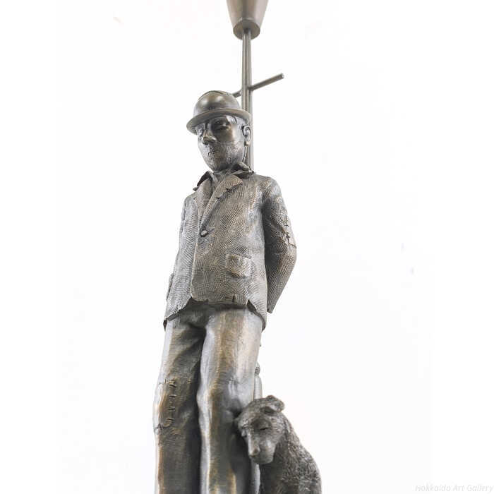 物思いにふけるように静かに寄り添う人と犬の姿。その普遍的な絆が、温かく、そしてどこか懐かしい物語をそっと描き出しています。専用箱・作品証明書付属2004年制作、限定395部技法：ブロンズ・レジン彫刻外寸：高さ41×幅15×奥行き15cm作品の状態：作品は良好です。箱は折れ、若干の潰れがあります。ポール・ホートン（Paul Horton）＜略歴・情報＞1958イギリス、バーミンガムに生まれる1970画家としての活動を開始（独学で技術を磨く）1974バーミンガム・ボーンビル・カレッジ・オブ・アート（Bournville College of Art）入学1976美術教育を修了し、プロフェッショナルな制作活動へ移行1980この頃、自身の代表的なスタイルである「Working Man」や「Street Scenes」を確立1998バーミンガム・ロイヤル・ソサエティ・オブ・アーティスト（RBSA）の正会員に選出2001大手美術出版社 Washington Green と契約2002作品集「The Journeyman」を出版2003イギリス国内の主要ギャラリーにて巡回展を開催2004「The Art of Giving」プロジェクトに参画2006ロンドン・アレクサンドラ・パレスにて大規模個展を開催2011画家生活35周年を記念した回顧展を開催2014オリジナルキャラクターを用いた彫刻作品のシリーズを発表2017独立系アーティストとして自身のブランド「Horton Fine Art」を設立2018バーミンガム周辺の産業遺産をテーマにしたシリーズを発表2023画業50周年を記念するエキシビションを英国各地で開催＜所属＞ロイヤル・ソサエティ・オブ・アーティスト（RBSA）正会員＜特徴＞色彩豊かなパステルや油彩を使い、労働者階級の日常、家路につく人々、愛、希望といった普遍的なテーマを描く。擬人化されたキャラクターや、幻想的でありながらどこか懐かしい街並みが世界中のコレクターに愛されている。＜作品収蔵＞バーミンガム市立美術館、イギリス国内の多数の個人および公共コレクション注意事項：お使いのモニターの発色具合によって、実際のものと色が異なる場合がございます。