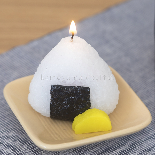 商品説明サイズ小函寸法：W94×L94×H73mm本体寸法：W92×L92×H72mm メーカーカメヤマローソク 備考火を灯すと中に梅干が入っています。たくあん付き。 ※メール便不可商品です。列車の旅には、お茶と冷凍みかんとおむすびが定番だったあの時代に食べた「おむすび」をイメージしました。 パッケージには当時を彷彿させる心にくいイラストが添えられ、 古きよき昭和の時代がよみがえるキャンドル。火を灯すと中から梅干が出てきます。 お味噌汁や緑茶キャンドルとセットにするのがおすすめです。 火を灯せば、おいしそうなおむすびの中に梅干が入っています。 海外へのお土産やユニークなプレゼントにぴったりです。 たくあんも付いていて、どこか昔懐かしい雰囲気を思い出させてくれます。 小函寸法：W94×L94×H73mm 本体寸法：W92×L92×H72mm メーカー：カメヤマローソク 【故人の好物シリーズ】 ※各画像をクリックで商品ページへ