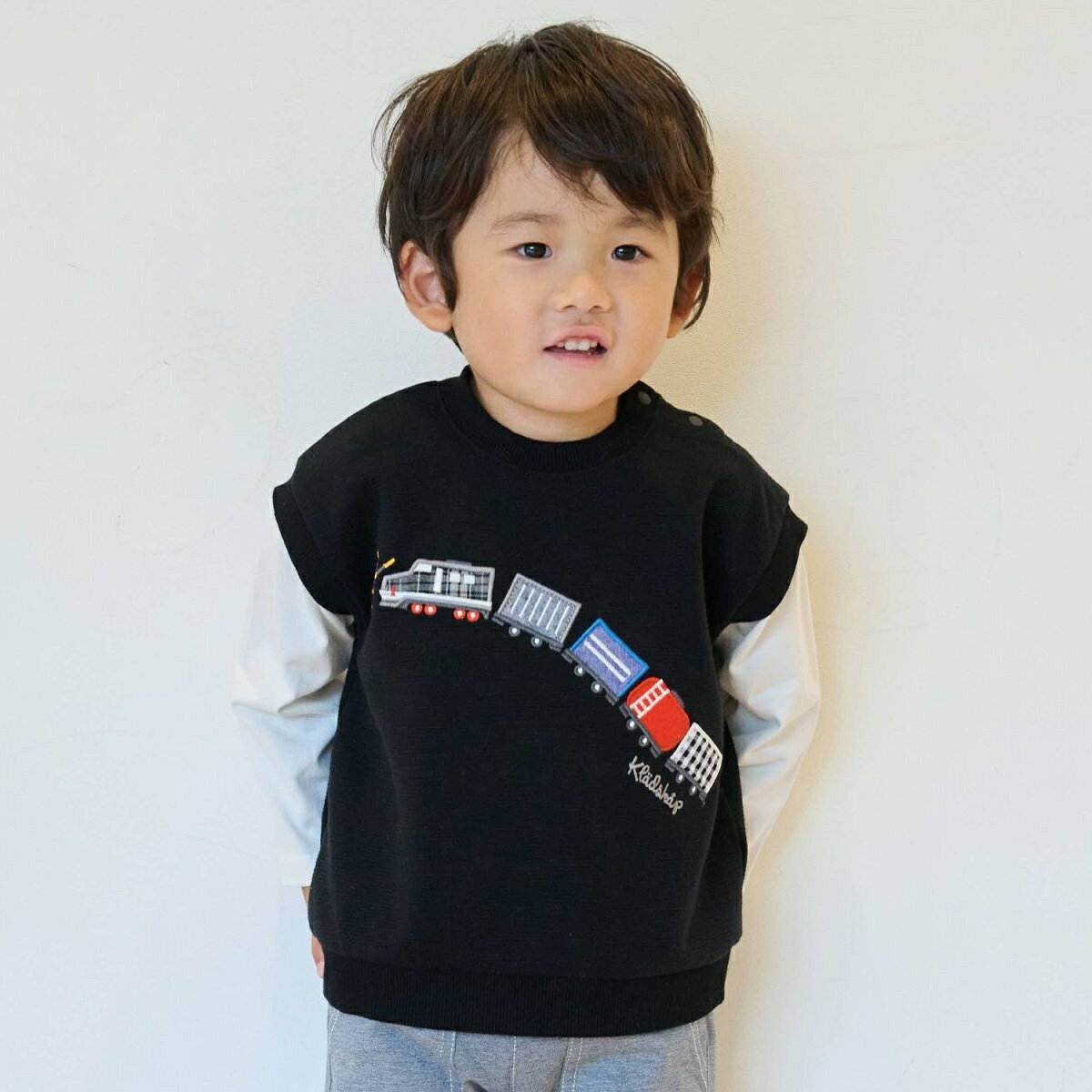 [型番：5353222]ベストをレイヤードしているようなデザインのプルオーバーです。ユニークなアップリケとバックネックの電車刺しゅうが魅力的。ベースはシンプルな配色なので、キレイめコーデにもオススメです。さまざまなボトムに合わせやすく、着回しが利きます。内側にお名前を記入できるタグつき。刺しゅうの裏に「あて布」はございません。※80、90サイズのみ肩開き【透け感】透けない【生地の厚さ】普通【伸縮性】あり【裏地】なし【ポケット】なし黒：モデル身長：93cm 着用サイズ：90cm ■カラー：黒、シロ杢サイズ：着丈×胸囲×肩巾×袖丈80cm：33.5×66×31×22.590cm：35.5×68×32×26100cm：39×72×34×30110cm：43×76×36×34120cm：47×80×38×38※(　)で表記されている数字はヌードサイズです。ヌードサイズとは衣服を身につけない身体のサイズです。お客様ご自身の身体サイズと比較してお選びください。 ■素材： 本体：ポリエステル64%本体：綿32%本体：ポリウレタン4%袖部分：綿100%リブ部分：綿93%リブ部分：ポリウレタン7% ■お手入： 洗濯方法は商品タグをご確認ください&nbsp;&nbsp;>>商品のお取り扱い方法 ■原産国： 中国電車アップリケベストレイヤード風プルオーバー／クレードスコープ（kladskap）黒シロ杢画面上と実物では、多少色具合が異なって見える場合がございます。