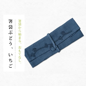 商品名 箸袋ぶどう、いちご サイズ 縦23.5cm ×　30.5cm ※止めヒモの長さは40cmです。 ※ホルダー部分は3ケ所です。（ナイフ、フォーク、お箸がセットできます） ※製品染めの為サイズに多少誤差があります。 材質 綿88%　麻12%ワッシャー仕上げ　 洗い方 中性洗剤　手洗い　陰干し 製造会社 株式会社ナック・インターナショナル箸袋ぶどう、いちご 食卓のおもてなしに最適のアイテムの箸袋です。 ナイフ、フォーク、お箸をセットしてさりげなくおもてなし。かわいい箸袋が、食卓の雰囲気を高めてくれます。 あなたの心配りを相手に伝え、ホルダーから取り出すその瞬間までドキドキ感を演出してくれるアイテムです。 麻のブレンド素材を使ってパリッとした素材感を出したお箸のホルダーです。 製品の隅々まで手創りで丁寧に仕上げています。 素材の変化と、ポイントのモチーフレースがワクワク感を誘います。止めヒモは花をモチーフとしたワンポイントになっています。 時間のかかる手染めの色付けは、一つ一つを手作業で仕上げた手のかかった逸品。手付けのモチーフレースは、いちごとぶどうの2種類がデザインされています。 13色のカラーからあなたのイメージで組み合わせをチョイスしてください。 手染めの箸袋をテーブルの上で 「おもてなしとして魅せる」 「和の雰囲気を演出する」 ための道具として提案しました。 また、カンタンな箸置きとしても使えるように、多用途の小物雑貨として提案をしています。 来客時のおもてなしの時の演出にぜひお使いください。それだけで食卓の雰囲気がグレードアップ、人数によってカラーを変えて演出も可能です。 和，洋、中、どんな料理のときでもピッタリです。 お店などで使われる場合は、ご使用後、お客様へプレゼントすると、きっと喜ばれることでしょう。お店のPR、口コミの材料にもなります。 多人数での特別な会食にもフルカラーで演出、オシャレな記念品にもなります。