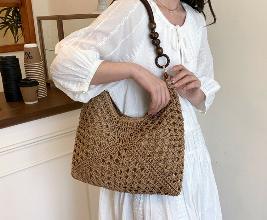 夏の爆発的なモデルの草編みバッグの女性の2025新モデルのビーチのビーチの透かし彫りのショルダーバッグを手で編みますトートバッグ