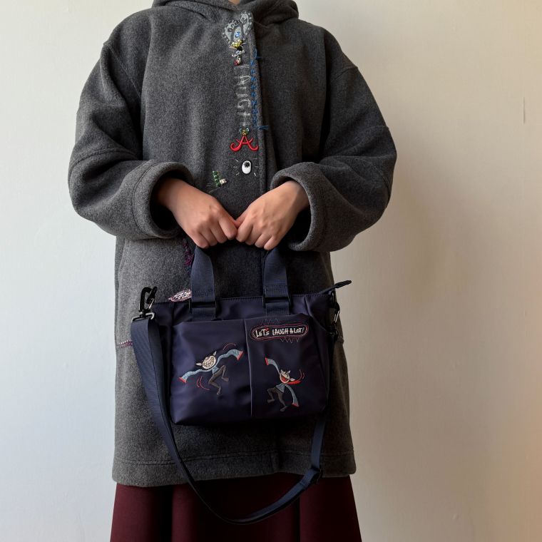 アルベロベロ /オレボレブラ2026 WINTER COLLECTION(冬物コレクション）前面＆後面にポケットが付いているスモールポケットバッグ。ポケットにスマホやパスケース等をサッと入れることができ、とっても便利！取り外し可能な肩掛けベルトが付いていて、手提げ＆ショルダーの2WAYで楽しんでいただけます。前面のポケットには可愛いぶたさんの刺繍入りで、目を引くポイントになっています。開閉はファスナータイプで、荷物の出し入れもスムーズ。内側には小物を入れられるポケットが3つ付いています。(1箇所はファスナー付き）ナイロン製で軽量、しかも表面は撥水仕様。弱めの雨の日なら持っていただくことが可能です。ちょっとそこまでのお出かけ、通勤、ご旅行の際のサブバッグ等として使いやすいスモールバッグとなっています。＊合わせているコート（別売り）はこちらから！＊合わせているコート、スカートは付属しません。＊肩掛けベルトの長さは調節が可能となっています。 コーディネートお勧めアイテム Specサイズ ：W30cm　H18cm　D9cm素材 ：ナイロン100％　撥水　（裏地）ポリエステル100％ カラー ：Aコン　Bクロ洗濯 ：水洗い不可 メーカー希望小売価格はメーカー商品タグに基づいて掲載しています　