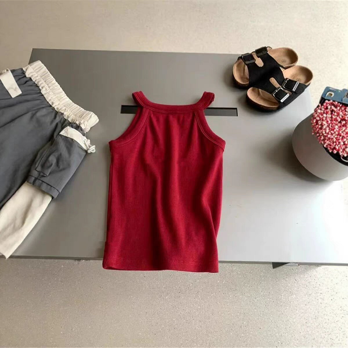 対象年齢：ベビーキッズジュニア（80cm～140cm）性別：男女兼用素材：ポリエステルカラー：レッド / ネイビー / グレー / パープル / イエロー / ホワイト / オレンジ（全 7 色）特徴：無地、太め肩ひも、通気性吸汗性、伸縮性、洗濯耐久性、インナーアウター兼用こちらは、夏のコーデに欠かせない、肌触りの良い無地キッズキャミソールです。7 色の豊富なカラーバリエーションで、どんなボトムスにも合わせやすく、重ね着にも大活躍します。デザインシンプルなホルターネックデザインで、肩ひもが太めでズレにくく、お子様の動きを邪魔しません。無地のシンプルデザインなので、カジュアルコーデからフォーマルな場面まで、幅広く対応できます。インナーとしてもアウターとしても使える、夏の万能アイテムです。
