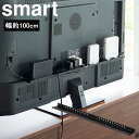 商品名 smart テレビ裏ラック スマート ワイド100 カラー（型番） ブラック（3631） 商品サイズ 約W100×D8.2×H3cm 重量 約1450g 内寸サイズ 約W100×D8cm 素材 本体：スチール(粉体塗装) 付属品 テレビ背面固定用ネジ(M4×10mm・M6×10mm・M8×15mm)×各2 M4ネジ用ワッシャー×2 六角レンチ 耐荷重 約3kg 対応サイズ テレビ背面のネジ穴ピッチ：横20～75cm(2.5cm間隔) VESA規格対応の50～65インチのテレビを目安としています。 原産国 中国 JAN ブラック：4903208036313 説明 テレビ裏のスペースを有効活用できるラック。 ルーター・外付けHDD・電源タップなどをテレビ裏にスッキリ一括収納。 テレビ裏のスペースに、よく使う掃除用品やゲームコントローラーを隠して収納。 テレビ周りをスッキリと整理整頓。 テレビの背面に簡単取り付け。 隠して収納ができてスペースを有効活用。 VESA規格対応。 テレビ裏のネジ穴にねじ込んで固定するだけなので簡単に設置ができます。 ※ルーターやゲーム機等は付属しておりません。 ブラック：97008117■ smart テレビ裏ラック スマート ワイド100 テレビ裏のスペースを有効活用できるラック。 ルーター・外付けHDD・電源タップなどをテレビ裏にスッキリ一括収納。 隠して収納ができてスペースを有効活用。