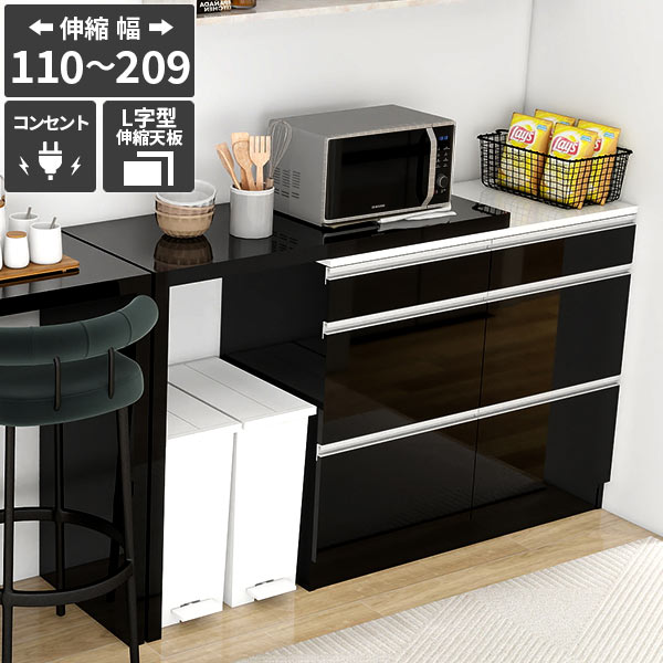 RDW-1203/PlusOneL字 blackサイズ約幅1100〜2098 奥行445 高さ945 mm材質【レンジ台】[天板・前板・側板]メラミン樹脂化粧合板[背板]プリント化粧合板※天板は120℃までの耐熱処理と耐水処理[取っ手]ABS樹脂【伸縮天板】メラミン樹脂化粧合板カラーブラック※環境によって異なって見える場合がございます。重量約69kg仕様耐荷重：約天板50kg/引出し(小)3kg/引出し(中・大)10kg日本製レンジ台：完成品伸縮天板：組立品背面化粧仕上げ(一部タッカー留め)コンセント2口(合計1500W)伸縮天板：床キズ防止フェルト/六角レンチ付属ブランド　送料送料無料※北海道・沖縄・離島は送料別途お見積もり。納期ご注文状況により納期に変動がございます。最新の納期情報はカラー選択時にご確認ください。※オーダー商品につき、ご注文のキャンセル・変更につきましてはお届け前でありましても生産手配が済んでいるためキャンセル料(商品代金の50％)を頂戴いたします。※商品到着までの日数は、地域により異なります※ご購入時にお届け日の指定がない、または指定不可商品の場合、最短日での出荷手配を行いメールにてご連絡させていただきます。配送・開梱設置について※北海道・沖縄・離島は送料別途お見積もりいたしましてご連絡いたします。【ご注意ください】離島・郡部など一部配送不可地域がございます。配送不可地域の場合は、通常の配送便での玄関渡しとなります。運送業者の便の都合上、地域によってはご希望の日時指定がお受けできない場合がございます。建物の形態（エレベーターの無い3階以上など）によっては別途追加料金を頂戴する場合がございます。吊り上げ作業などが必要な場合につきましても追加料金はお客様ご負担です。サイズの確認不十分などの理由による返品・返金はお受けできません。※ご注文前に商品のサイズと、搬入経路の幅・高さ・戸口サイズなど充分にご確認願います。→　詳しくはこちら備考※製造上の都合や商品の改良のため、予告なく仕様変更する場合がございますので予めご了承ください。当店オリジナル家具を全部見る管理番号0000ae039702/-メラ-bk/メーカー希望小売価格はメーカーカタログに基づいて掲載していますこのページは RDW-1203/PlusOneL字 black のページです。伸縮天板付きの電子レンジボード1台あれば、キッチンラックや食器の収納として役立つお洒落な国産キッチンカウンター。カウンターキッチンやバーカウンターとしても便利な高さで、使い勝手抜群です。レンジボード本体は完成品でお届けし、組み立て不要ですぐに使えるのもポイントです。大型電子レンジ台も対応スチームオーブンレンジなどの大型電子レンジも設置可能で、伸縮天板でスペースを無駄なく活用！ホワイト鏡面の天板は120℃までの耐熱・耐水処理を施した熱・傷・水・汚れに強いアイカ製のメラミン樹脂化粧合板を使用しており、熱い鍋やフライパンを置いても大丈夫。キッチンボードとしてだけではなく、作業台としてもおすすめ。レンジ台3つのポイントスライドレール付き引き出しキッチン小物の整理には欠かせない、カトラリー類や調味料の収納に便利な薄型の引出しと、2Lペットボトルのストックなどに便利な大型引き出し。鍋や食器収納としても使用可能です。それぞれスライドレール付きで楽々オープン。[使用商品] RDW-002(木目ダークブラウン)水分やキズや汚れに強い天板ホワイト鏡面の天板はアイカ製のメラミン樹脂化粧合板を使用しています。海外製の安価なものとは異なり、高品質で質の良いメラミンはキズや汚れに強いので、汚れたら濡れた布でサッと拭くだけでOKです。[使用カラー] 木目ダークブラウン2口コンセント付き天板の右上にコンセント2口(合計1500Wまで使用可能)が付いています。炊飯器や電気ケトルなどの電源に最適です。伸長できるL字型テーブルが付属レンジ台にPlusOne(プラスワン)できるテーブルが付属。あとちょっと収納スペースが欲しい、作業台が欲しい・・・そんな「あとちょっと」を叶える天板です。ダストボックスをテーブル下に収納して無駄なスペースを有効活用したり、自由に伸縮できるのでいろんな場所にピタっと収まるので隙間収納にも。[使用商品] 左：RDW-002/PlusOneL字(Marble)、右：RDW-1203/PlusOneL字(Black)伸縮テーブル2つのポイントラメロ社製の金具で美しい見た目厚さ4cmで頑丈な板にラメロ社製の強度の高い金具を使用したカンタン組み立て品。組み立て用の六角レンチが付属しています。[使用カラー] 木目ホワイト自由に伸縮可能デッドスペースになりやすいゴミ箱の上のスペースに合わせて広げたり、便利な調理補助台としてお使いいただけます。不要な時は伸長幅を最小にすることで省スペースにできて自由自在です。※物を載せた状態で移動はしないでください。また、引きずるように移動させると床に傷ができる可能性がございます。[使用商品] RDW-003/PlusOneL字(木目ホワイトウッド)コーディネートシーンSCENE.1豊富な収納を兼ね備えたキッチン収納コーヒーマシン、トースターなどのキッチン家電収納や、キャビネットや引き出しは食器棚としてもお使いいただけます。電気ポットなどの使用頻度の高い家電はスライド棚に収納することで必要な時だけさっと取り出せます。邪魔になりやすいごみ箱もテーブル下に置くことでキッチンスペースを有効活用。コンパクトながら収納力があり、使い勝手がよく、キッチンをいつでもスッキリと保てます。一人暮らしの方にもぴったりのキッチン家具です。[使用商品] 上：左RDW-003/PlusOneL字(Graystone)、右RDW-1203/PlusOneL字(Graystone)、下：RDW-002/PlusOneコの字(Blackpearl)SCENE.2テーブルや作業デスクとして使用自由に伸縮できるテーブルは、キッチンカウンターテーブルやパソコンデスク、ドレッサーとしてもお使いいただけます。ハイタイプなのでカウンターチェアが合わせやすい高さです。収納スペースが豊富で本棚や消耗品のストック等にも便利です。効率的な作業環境作りにおすすめ。自宅のワークスペースや書斎、リビングのインテリアにも合わせやすいおしゃれでシンプルなデザイン。[使用商品] 上：左RDW-1203/PlusOneコの字(Nail)、下：RDW-003/PlusOneL字(Whitewood)SCENE.3大容量収納で玄関の収納やコンソールテーブルにもインテリアと実用性を兼ね備えた、エントランスの収納やコンソールデスクとしても活用できます。スリムな約奥行45cmで伸縮天板で幅の調整ができるため、限られたスペースにもすっきりと収まります。大容量のチェストは、日用品や細かな小物を扉付きですっきり整理でき、リビング収納としてもおすすめです。伸縮天板は電話台や花台として使用したり、下の空間には傘立てなども収納可能です。[使用商品] 上：左RDW-1203/PlusOneコの字(Black)、下：RDW-003/PlusOneコの字(Marble)
