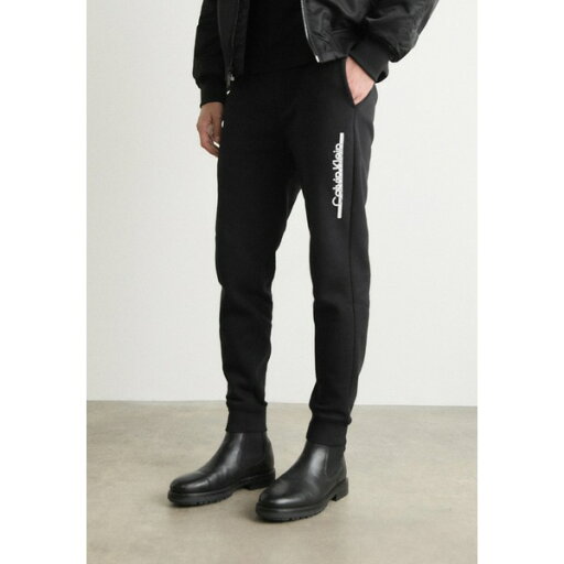 カルバンクライン メンズ カジュアルパンツ ボトムス SPLIT LINE LOGO - Tracksuit bottoms - black カルバンクライン メンズ カジュアルパンツ ボトムス SPLIT LINE LOGO - Tracksuit bottoms - black