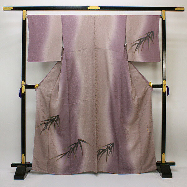 適応シーン結婚式二次会、パーティー、お茶会、同窓会、あつまり 適応シーズン1月〜5月、10月〜12月 状態新品 当店にてお仕立て済（手縫い仕立て） 正絹胴裏 素材正絹 丹後ちりめん サイズM寸 身丈(背より)：約 157cm / 後巾、前巾：柄合わせ優先 / 袖丈：約 49cm / 裄：約 66.5cm / 袖巾：約 33.5cm 地色半色（ソフトパープル）系 備考フォーマル用にどうぞ ※パールトーン加工をお伺いする場合のお支払方法は代金引換以外でお願いいたします。 ◆オプションは下記商品ページよりご購入下さい◆ ⇒ 【お仕立て上がり】【袷】訪問着・付下げ パールトーン加工 当店でお誂え致しましたお仕立て上がり付下げ訪問着でございます。 胴裏も正絹を使用し、手縫い仕立てで仕上げましたので、一格上のお品です。 届いてすぐにお召頂けるのが嬉しいですね。 絹らしい光沢がシボに輝き、しっとりと滑らかな質感はエレガントな着姿を表現してくれます。 大きな変わり唐草の地紋は光加減で輝きを放ち、グラデーションの色合いがお洒落度を増し、さらりとした質感が心地よく高級感もございます。 笹のお柄もインパクトがあり、とてもお洒落。 金彩加工が高級感を放ちます。 季節を問わず、帯によって御召いただける場や年齢が広がります。