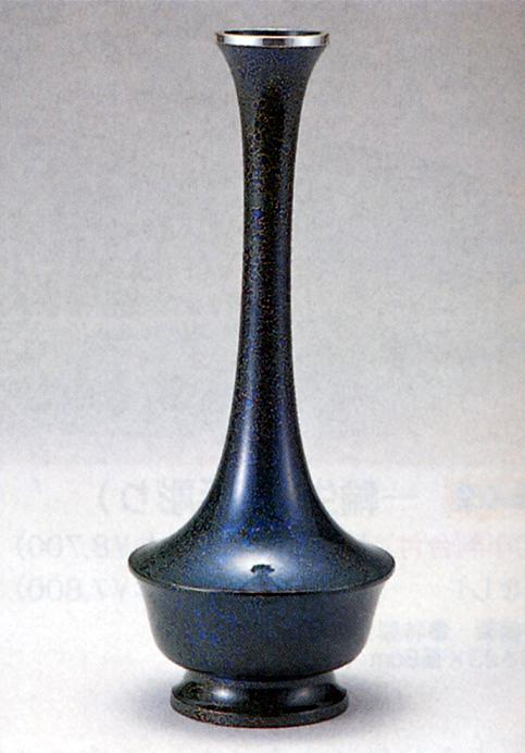 高岡銅器　花器・花瓶 素材 青銅（ブロンズ）製 作者 瑞峰 サイズ（センチ） 高さ約24．8×幅：約9．8×奥行：約9．8 高岡銅器 高岡銅器は、1611年二代目加賀藩主前田利長が、高岡築城に際し、城下の繁栄をはかる産業政策として鋳物師を招き、鋳物工場を開設した事が始まりです。 花器、仏具等の鋳物に彫金を主体とする唐金鋳物を作り出したことにより発展し、明治期にはパリ万国博覧会などで世界的に名を馳せました。 昭和50年には、日本で最初に国の伝統工芸品産地の指定を受け、新商品の開発・需要の開発・人材の養成に努めています。 製品は卓上置物から、ブロンズ像、大仏にまで及び全国の生産量の90％以上を占めています。 ※ 高岡 銅器 銅製 ブロンズ 青銅 鍛造 かき かびん 花入れ 花生け 華道具 華道 茶道具 茶道 茶花 花入れ 花鋏 薄端 うすばた 釣船 獅子口 水盤 広口 細口 インテリア花瓶 インテリア花器 仏具 三具足 五具足瑞峰作 青銅(ブロンズ)製紙箱入り