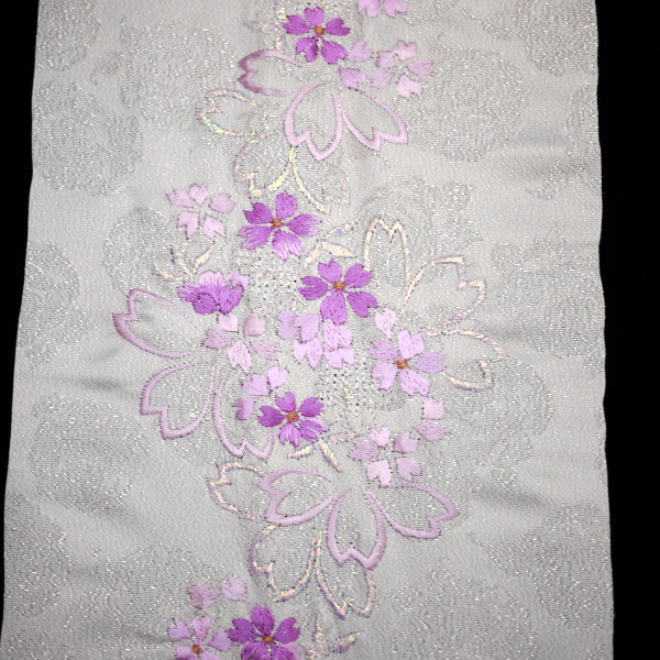 振袖、訪問着等に豪華な刺繍の半衿。 地柄にラメを施した薔薇柄がとうても豪華で素敵な逸品です。 【色柄】白地に豪華な薔薇柄、ラメ入り。パープル系の桜柄の刺繍。 【素材】ポリエステル100％