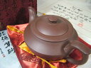 サイズ：全長185×高（フタ込み）90×幅120mm　重さ：370.5g　 付属品：専用布張り箱・高級錦織巾着袋・製作者自筆證書（保証書）・作品冊子　 ◎お茶をいただく場合に欠かせない道具が、湯呑み等の茶器です。中国では茶器というと茶壼（急須）を指し、それは只の茶道具ではなく、茶文化の起源地である中国ではとても貴重なアイテムです。紫砂（しさ）は、中国江蘇省の宜興（イーシン）で産出する深い紫色をしている土のことで、これで作られた紫砂茶壺は、およそ千余年の歴史をもち昔から最高の道具として珍重されてきました。その色と造形は古風ですが、何とも温かみの有る素朴さがあり、茶の味を一段と引き立てると共に、奥深い中国伝統文化の一面も見せてくれます。 ※画像3右上は底面に押されている作者印です。 ●宜興「紫砂茶壷」：実用価値の外に芸術的価値が高い訳は、その土が独特だからである。紫砂は鉄分の含有量が高いため堅く、ロクロでは作成出来ず、棒で叩きながら制作する。更に普通の茶壼は、釉薬（うわぐすり）が掛かっている為、味や香りが茶壼に残ることはないが、宜興の紫砂茶壺は釉薬をかけない素焼きである。素焼き器の中には多数の気孔（穴）が出来る為、同じ茶を繰り返し淹れることで、これらの気孔が茶の渋みや雑味を吸収し、茶を引き立てるのは勿論、香りが紫砂壺全体に馴染み、また紫砂壺自体も光沢が増す（香りを吸収し易いからこそ別種類の茶葉を淹れるのは良くない）。紫砂壺は我が子を慈しむように使っていくと、もっとおいしく茶を淹れられるように育って行く。これを「養壼（ヤンフー）」と言い、親から子に代々伝えられ家宝とされている。※当商品の通常発送はヤマト運輸の宅急便とさせて頂きます。◎宅急便は発送先により送料が変わります。この場合は当方から改めまして合計金額をお知らせさせて頂きますので、必ずご確認下さいますようお願い致します◎　※代引き発送を御希望の場合は、諸費用で1000円をお願いしております。　※当方から合計金額等のメールを送信後、1週間以内に御振り込み、もしくは御返信を頂けなかった場合はキャンセルとさせて頂きます。　※こちらの商品を御注文頂きます時に、支払方法を「代引発送」にされますと、楽天から自動送信されますメールにはシステム上、代引き料金が350円と記載される事が御座います。この場合は龍香堂から改めまして合計金額をお知らせさせて頂きますので、必ずご確認下さいますようお願い致します。