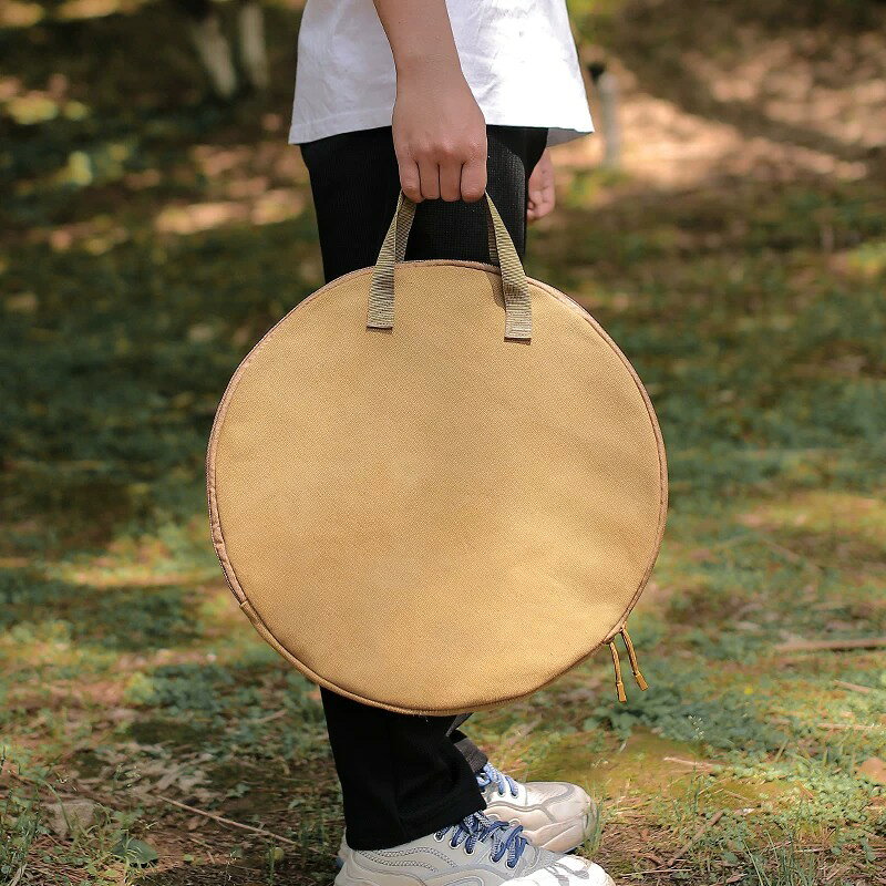 BADUSのグリルパン収納バッグは、アウトドアやBBQで使う丸型グリルパン、フライパン、鉄板などを持ち運びやすくする手提げタイプの収納バッグです。源画像では、丸型バッグ、布製の持ち手、側面収納ポケット、ブラックとカーキの2色を確認できます。サイズ目安は約45.5×35.5cm、持ち手は約17cm、重量は約244gです。収納できる器具は外径、厚み、取っ手形状によって変わるため、お手持ちの器具サイズを確認してからお選びください。カラーはブラックとカーキです。キャンプ場への移動、車載保管、使用後の道具整理、棚や物置での保管などに使いやすい収納バッグとして案内します。バッグ単品の商品として扱い、鍋、鉄板、フライパン、カトラリーなどが付属するとは記載していません。火気や高温の器具を直接入れず、十分に冷ましてから収納してください。使用後は汚れや水分を拭き取り、乾燥させて保管してください。防水等級、耐熱温度、耐荷重、完全密閉など、元情報で確認できない性能は断定していません。