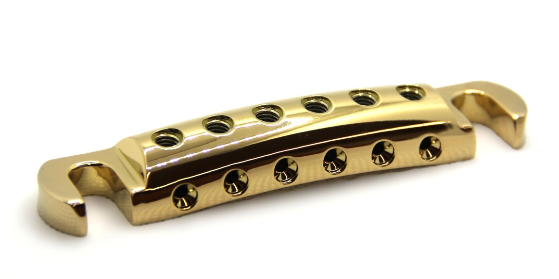 PRODUCT DETAILS Steadfast Custom ギター用 ストップバー テールピース ストリングロック機能 レスポール SG ES-335 24Kゴールド【商品仕様】・ ブランド：Steadfast・ 型番：Custom・ 品目：テールピース・ 形状：ストップバー・ 素材：6061ビレットアルミニウム・ 重量：約37g・ 対応スタッド：インチ（US）およびメトリック（輸入車）両対応・ 対応モデル：レスポール、SG、ES-335、エクスプローラー、フライングV等の2スタッド・トップマウント仕様のギター・ カラー：24Kゴールドメッキ・ 付属品：ステンレス製セットスクリュー（6本）、ブラックセットスクリュー（6本）、2.5mm専用ヘックスドライバー【特徴】・ 弦のボールエンドをペグ側に、自由端をテールピース側に固定する独自のストリングロック設計を採用しています。・ テールピース側で弦を固定することにより、ペグへの巻き数を最小限に抑え、弦交換の時間を大幅に短縮します。・ 6061アルミ材の削り出しにより、標準的な亜鉛ダイキャスト製（約88g）と比較して約37gと大幅な軽量化を実現しています。・ インチおよびメトリックの両スタッド間隔に対応しており、多くのTune-O-Matic搭載ギターに無加工でボルトオン装着が可能です。【ご注意】・ 取り付けには加工・配線作業が必要な場合があります。お手持ちの楽器との適合（弦数・サイズ・取付穴位置）をご確認のうえご注文ください。・ アクティブタイプのピックアップは9V電池が必要です（電池は付属しない場合があります）。 ■ 商品について 海外輸入品（説明書は英語表記の場合あり） ■ ご注意 ・掲載画像は実物に近い色味になるよう調整しておりますが、ご利用の環境により差異が生じる場合があります。・複数店舗で在庫を共有しているため、ご注文後に在庫切れとなる場合がございます。 ■ 納期について お届けの目安を必ずご確認ください。 海外正規ルート仕入れ品 海外ブランド ▼ 海外正規ブランド店 正規代理店 ▼ 当 店 ※本商品は並行輸入品です 製造元は正規品と同一のブランド・メーカーです。当店では海外正規ルートより仕入れた商品を取り扱っております。流通ルートが異なるのみで、商品自体に違いはございません。 ── 当店の商品について ── 正規品のみ取り扱い 海外正規店・正規代理店から商品を直接仕入れ、国内に輸入して販売しております。 日本未入荷・海外限定モデルも多数 日本未入荷・海外限定モデルも多数取り扱っております。サイズ・カラー違いや海外限定で販売された製品など、日本では手に入りにくいアイテムをお届けいたします。 お求めやすい価格の理由 海外市場での価格差や流通ルートの違いにより、国内販売価格よりお求めやすくなっております。品質はそのままに、よりお手頃な価格でお届けいたします。 安心保証 ご使用前に万が一、製品に不具合がございました場合は、交換または商品代金のご返金にて対応させていただきます。商品到着後5日以内にご連絡ください。 ご注意 海外からの輸入品となります。海外輸送のため、外箱に軽微なスレ等がある場合がございますが、商品本体には影響ございません。 ※在庫状況は仕入先の在庫情報をもとに出来る限り正確に表示しておりますが、取寄せ商品のため、タイミングによりご注文後に欠品・キャンセルとなる場合がございます。 お探しの商品がございましたら、お気軽にご相談ください。
