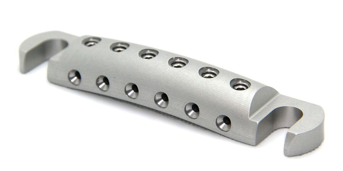 PRODUCT DETAILS Steadfast Stopbar Faded ギター用 テールピース ストップバー ストリングロック レスポール SG ES-335等 シルバー【商品仕様】・ ブランド：Steadfast・ 型番：Stopbar Faded・ 品目：ギター用テールピース（ストリングロック式）・ 材質：6061アルミニウム（削り出し）・ 弦間ピッチ：インチ（米国）・ミリ（輸入）両規格のスタッド間隔に対応・ 重量：約37g・ 対応モデル：Gibson, Epiphone, Gretsch, ESP/LTD, Ibanez, Schecter, EVH, Heritage, Reverend, Yamaha等のレスポール、SG、ES-335、Explorer、Flying Vなど・ カラー：シルバー（アノダイズド・サテン仕上げ）・ 付属品：ステンレス製セットスクリュー×6、ブラックセットスクリュー×6、2.5mm専用レンチ【特徴】・ 弦を逆向きに装着し、テールピース側のスクリューで固定する世界初のストリングロック・システムを採用しています。・ ペグ側での弦の巻き数を最小限に抑えることで、弦交換の時間を短縮し、演奏中のチューニングの安定性を高めます。・ 6061アルミニウムの削り出しにより、標準的な亜鉛ダイキャスト製パーツ（約88g）と比較して約37gと大幅な軽量化を実現しています。・ 弦を固定するセットスクリューは平らな面で接触する設計となっており、弦を傷つけることなく確実にクランプします。【ご注意】・ 取り付けには加工・配線作業が必要な場合があります。お手持ちの楽器との適合（弦数・サイズ・取付穴位置）をご確認のうえご注文ください。・ アクティブタイプのピックアップは9V電池が必要です（電池は付属しない場合があります）。 ■ 商品について 海外輸入品（説明書は英語表記の場合あり） ■ ご注意 ・掲載画像は実物に近い色味になるよう調整しておりますが、ご利用の環境により差異が生じる場合があります。・複数店舗で在庫を共有しているため、ご注文後に在庫切れとなる場合がございます。 ■ 納期について お届けの目安を必ずご確認ください。 海外正規ルート仕入れ品 海外ブランド ▼ 海外正規ブランド店 正規代理店 ▼ 当 店 ※本商品は並行輸入品です 製造元は正規品と同一のブランド・メーカーです。当店では海外正規ルートより仕入れた商品を取り扱っております。流通ルートが異なるのみで、商品自体に違いはございません。 ── 当店の商品について ── 正規品のみ取り扱い 海外正規店・正規代理店から商品を直接仕入れ、国内に輸入して販売しております。 日本未入荷・海外限定モデルも多数 日本未入荷・海外限定モデルも多数取り扱っております。サイズ・カラー違いや海外限定で販売された製品など、日本では手に入りにくいアイテムをお届けいたします。 お求めやすい価格の理由 海外市場での価格差や流通ルートの違いにより、国内販売価格よりお求めやすくなっております。品質はそのままに、よりお手頃な価格でお届けいたします。 安心保証 ご使用前に万が一、製品に不具合がございました場合は、交換または商品代金のご返金にて対応させていただきます。商品到着後5日以内にご連絡ください。 ご注意 海外からの輸入品となります。海外輸送のため、外箱に軽微なスレ等がある場合がございますが、商品本体には影響ございません。 ※在庫状況は仕入先の在庫情報をもとに出来る限り正確に表示しておりますが、取寄せ商品のため、タイミングによりご注文後に欠品・キャンセルとなる場合がございます。 お探しの商品がございましたら、お気軽にご相談ください。