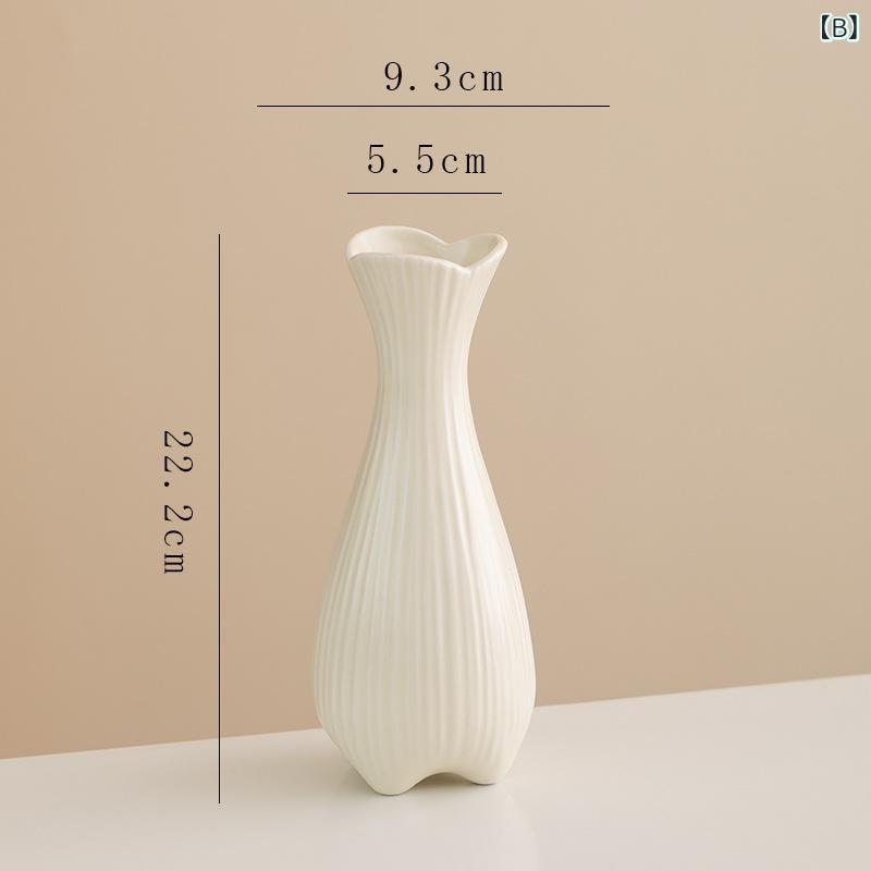 道中の シンプルな 創意 クリーム 風 陶磁器の 花瓶に 生け花が 飾ら れて います。