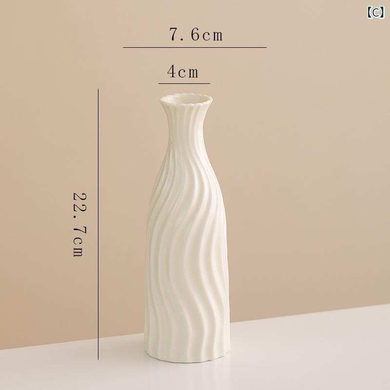 道中の シンプルな 創意 クリーム 風 陶磁器の 花瓶に 生け花が 飾ら れて います。
