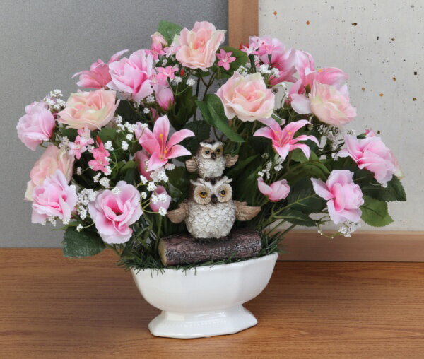 色彩豊かな花と幸運のふくろうオーナメント!!●華やかな「ローズ」、上品な印象の「ミニリリー」、全体を優しく包む「かすみ草」の組み合わせ●縁起の良い親子ふくろう●温度変化のエネルギーで消臭効果を発揮、CT触媒：浄化・消臭・防汚・抗菌●玄関に、リビングに、贈り物に●ピンク：愛情、人気運●サイズ：(約)幅38×奥行20×高さ30cm●重さ：(約)420g●素材／陶器、ポリエステル、発泡スチロール、アイアン、ふくろう：レジン