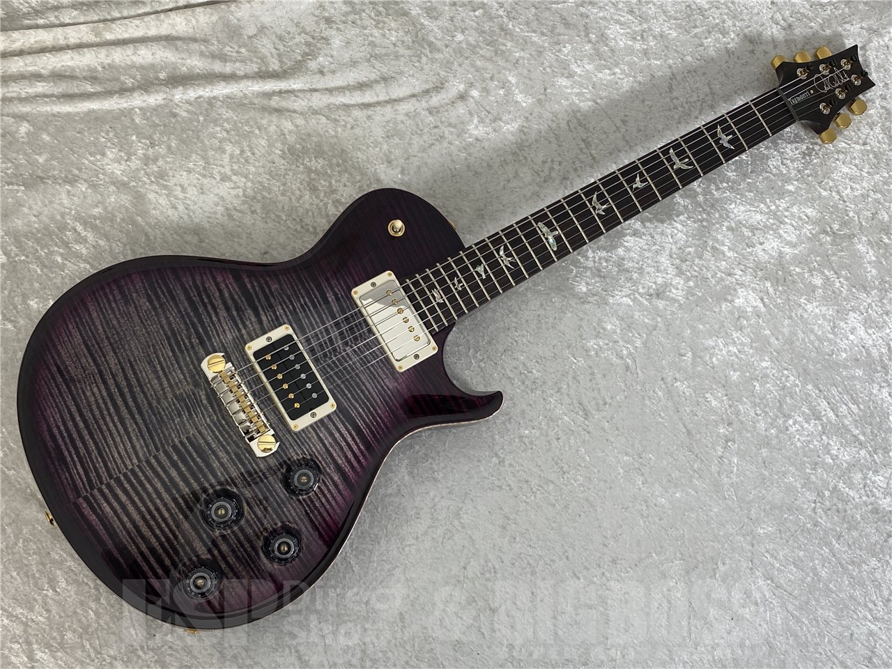 Creed、Alter Bridgeのギタリストとして成功し、今もギタリスト、ソングライターとして活躍するMark Tremonti モデルが入荷しました。こちらはアジャスタブルテールピースブリッジのモデルです。 Mark Tremontiはロック界をリードするギタリストの1人。Creed、Alter Bridgeのギタリストとして大成功し、今もギタリスト、ソングライターとして活躍中。Creedのデビュー・アルバム『My Own Prison』発表後のツアー中に、PRSギターを使ってみないかと打診されたのがMarkとPRSとの関係の始まりでした。 「PRSからオファーが来たときは、飛び跳ねて喜んだよ。高校や大学時代にはいくら欲しくたって買えないブランドだったからね」 PRSはMarkのもとへMcCartyモデルを送り届け、彼はすぐにそれを気に入り、一時期はMcMartyのみをプレイしていましたが、究極的には彼自身のプレイスタイルにマッチしたギターが必要だと感じるようになり、これがMark Tremontiモデルの出発点となりました。彼のオーダーは、パーム・ミュートを多用するバッキング時にもう少しパワーのあるピックアップにしたい、スラッシュ・メタルやシュレッド、トラディショナルなブルーズから影響を受けた彼自身のスタイルに合ったネックにしたい、というものでした。そして完成したのがパターン・シン・ネックのMark Tremonti Signatureです。 ■主な仕様 BODY Body Construction : Solidbody Top Wood : Maple Back Wood : Mahogany Top Carve : Violin NECK Number of Frets : 22 Scale Length : 25&quot; Neck Wood : Mahogany Neck Construction : One-Piece Truss Rod : PRS Double-Acting Neck Shape : Pattern Thin Neck Depth at the 1/2 Fret : 53/64&quot; Neck Depth at the 12 1/2 Fret : 57/64&quot; Neck Width at the Nut : 1 11/16&quot; Neck Width at the Body : 2 1/4&quot; Fretboard Wood : Rosewood Fretboard Radius : 10&quot; Fretboard Inlay : Birds Headstock Logo : Signature NECK/BODY ASSEMBLY Neck/Body Assembly Type : Set FINISH Finish Type : High-Gloss Nitro HARDWARE Bridge : PRS Patented Tremolo, Gen III with Trem-Up Route or Adjustable Stoptail Tuners : PRS Phase III Locking Hardware Type : Nickel Nut : PRS Truss Rod Cover : &quot;Tremonti&quot; ELECTRONICS Treble Pickup : Tremonti Bass Pickup : Tremonti Controls : Volume and Tone Control for Each Pickup and 3-Way Toggle Pickup Switch ADDITIONAL INFO Strings : PRS Signature 10-46 Tuning : Standard (6 String): E, A, D, G, B, E Case : Hardshell Case Options : 10 Top with Hybrid Hardware &nbsp; ※こちらの商品は実店舗BIGBOSSお茶ノ水駅前店でも販売しております。商品が販売された場合にはサイトからすぐ商品削除をするよう心がけておりますが、場合によってはすでに売却済みの場合もございます。 あらかじめご了承下さい。【BIGBOSS 8つの安心】当点リペアマンが弾きやすいようにセットアップしてお送りさせていただきます。ご購入後のメンテナンス・セットアップもいつでも無料です！くわしくはこちらをご確認ください。
