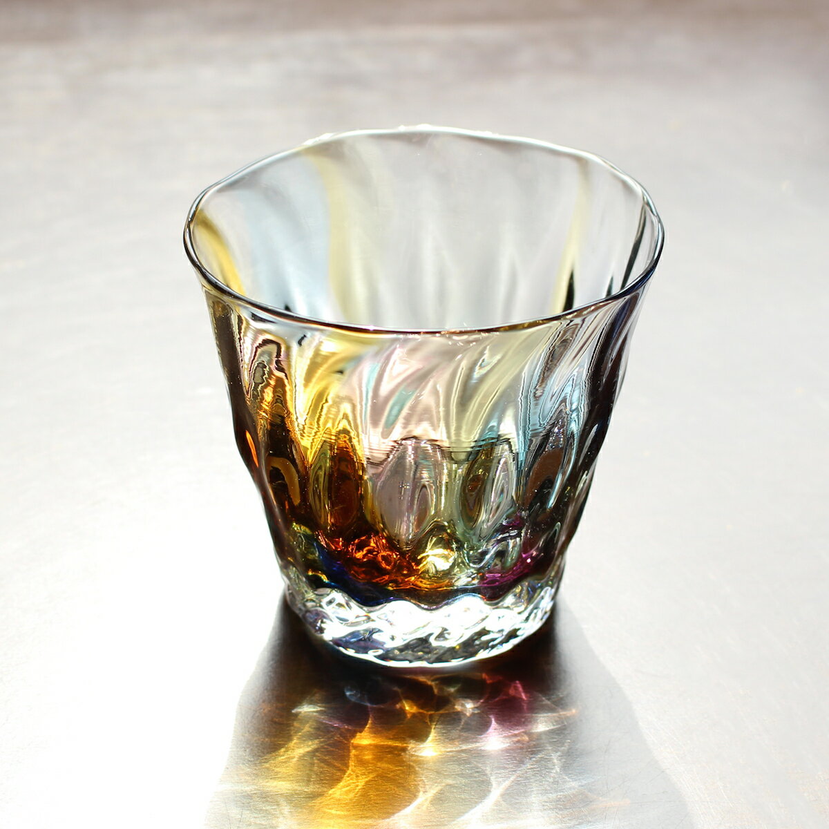 glass calicoの岩沢達さんによるハンドメイドのロックグラスです。アースカラーが織りなす透明感が美しく、自然の歪みに手仕事の温もりを感じます。テーブルに反射する色合いが素敵ですね♪