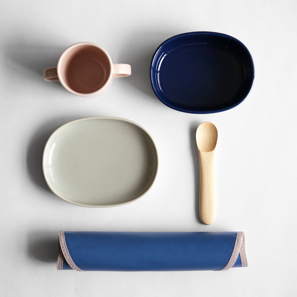 電子レンジ＆食洗機対応のマグカップ、ボウル、プレートと、メープル材で作られたスプーン、PVCコットン製のスタイの5点セット。3年以内であれば器を割ってしまっても無償で1度交換できる保証付きです。