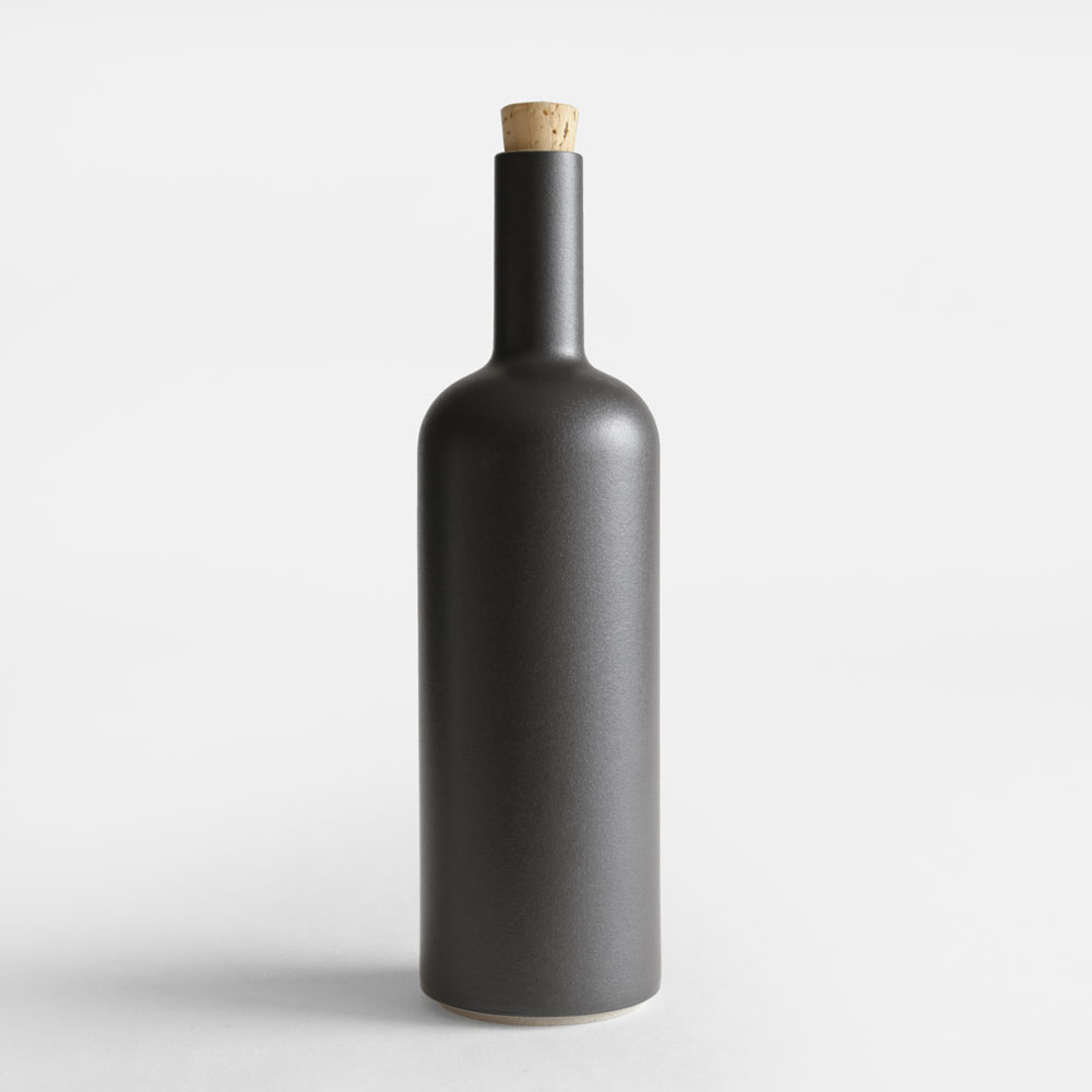 Brand : HASAMI PORCELAIN（ハサミポーセリン） Item : BOTTLE(Black) / HPB029 / ボトル 「HASAMI PORCELAIN」（ハサミポーセリン）は伝統的な遺産を現代的なコンセプトでデザインした波佐見焼のテーブルウェアシリーズです。ディレクションはアメリカ西海岸に拠点を置くデザイナー、篠本拓宏さんによるもの。全てのアイテムが一定のモジュールに従ってサイズ設計されているので、スタッキングや入れ子にして収納が可能になっていたりと機能的にも優れています。 【サイズ】：φ85×H300mm 【材質】：半磁器、コルク 【生産地】：長崎県波佐見町 日本有数の窯業の盛んな地、長崎県波佐見町。この地で約400年前の江戸時代につくられはじめた磁器は、当時から日本各地はもとより、長崎港を経てヨーロッパへも出荷されていました。早くから量産体制が整えられたため、日用の食器としての確かな質と価格を実現したことが知られています。豊かな伝統は、現代まで脈々と受け継がれ、HASAMI PORCELAINは、篠本拓宏（tortoise）のディレクションにより、こうした遺産を現代のコンセプトで革新するテーブルウェアとして生まれました。 HASAMI PORCELAIN（ハサミポーセリン）のアイテム一覧HASAMI PORCELAIN（ハサミポーセリン） 伝統的な遺産を現代的なコンセプトでデザインした波佐見焼のテーブルウェアシリーズ item:BOTTLE(Black) / HPB029 price:5,000yen+tax brand:HASAMI PORCELAIN（ハサミポーセリン） derection:篠本拓宏（tortoise） 「HASAMI PORCELAIN」（ハサミポーセリン）は伝統的な遺産を現代的なコンセプトでデザインした波佐見焼のテーブルウェアシリーズです。ディレクションはアメリカ西海岸に拠点を置くデザイナー、篠本拓宏さんによるもの。全てのアイテムが一定のモジュールに従ってサイズ設計されているので、スタッキングや入れ子にして収納が可能になっていたりと機能的にも優れています。 SPEC サイズ φ85×H300mm 材質 半磁器、コルク 生産地 長崎県波佐見町 波佐見から世界へ 日本有数の窯業の盛んな地、長崎県波佐見町。 この地で約400年前の江戸時代につくられはじめた磁器は、当時から日本各地はもとより、長崎港を経てヨーロッパへも出荷されていました。 早くから量産体制が整えられたため、日用の食器としての確かな質と価格を実現したことが知られています。豊かな伝統は、現代まで脈々と受け継がれ、HASAMI PORCELAIN（ハサミポーセリン）は、篠本拓宏（tortoise）のディレクションにより、こうした遺産を現代のコンセプトで革新するテーブルウェアとして生まれました。 アメリカで先行発売され人気となり、2011年に日本でも発売されて以来注目を集め、今ではスタンダードなテーブルウェアとして定着しています。 考え抜かれたモジュール設計 HASAMI HASAMI PORCELAIN（ハサミポーセリン）の器のサイズは、8.5cm、14.5cm、18.5cm、22cm、25.5cm、30cmのモジュールに従って設計されています。マグカップ、ボウル、トレイなど個々のアイテムが共通の直径でデザインされているため、自由なスタッキングが可能で、収納時や運搬時も無駄がありません。ニーズに合わせてスタッキングできる仕組みや、異なるサイズの器が入れ子で収納できる機能性は、日本料理のための伝統的な漆器である重箱からインスピレーションを得ています。重箱と同じように、室内でもアウトドアでも、単体でもセットでも、幅広いシーンで自由に使うことができます。 普遍性が宿る無駄のない佇まい HASAMI PORCELAIN（ハサミポーセリン）のフォルムには、一切の装飾性がありません。日本の伝統的な形態の根本でもある、潔くすっきりとした直線。機能と製造工程の必然性から導かれた、意味のある曲線。シンプルな線のみで構成されたデザインは、いくつもの器が重なり合い、フォルムがリピートすることで、いっそう美しい調和をつくり出します。「HASAMI PORCELAIN」（ハサミポーセリン）の無駄のない佇まいには、生活のための道具にふさわしい普遍性が宿っているのを感じます。 料理が映えるフォルムとカラー シンプルなフォルムとベーシックなカラー（ナチュラル、ブラック、グロスグレー）の器は料理を引き立ててくれます。まるで絵を描くように料理を盛り付けてお楽しみ頂けます。またサイズ展開が豊富ですので、あらゆる料理に対応したテーブルコーディネートが可能です。また電子レンジや食洗機も対応しておりますので、日常使いの器として気兼ねなくお使い頂けます。 触れた時の心地よさ HASAMI PORCELAIN（ハサミポーセリン）の魅力は、器が手や口に触れた時の感覚にある。陶器に比べて引き締まったシャープさがあり、通常の磁器よりも優しく有機的な感触が心地よい。独特の素材感によってもたらされるマットな風合いと色彩は、どんな食材と合わせても違和感がなく、フードやドリンクを引き立ててくれる。 HASAMI PORCELAIN（ハサミポーセリン）の素地は、天然の天草陶石からつくられる磁器の原料に、独自の比率で陶土を混ぜたもの。以前に波佐見で焼かれた陶磁器のサンプルを再現し、ありのままの素材感を生かす釉薬が配合された。 BRAND VARIATION こんな商品もおすすめ