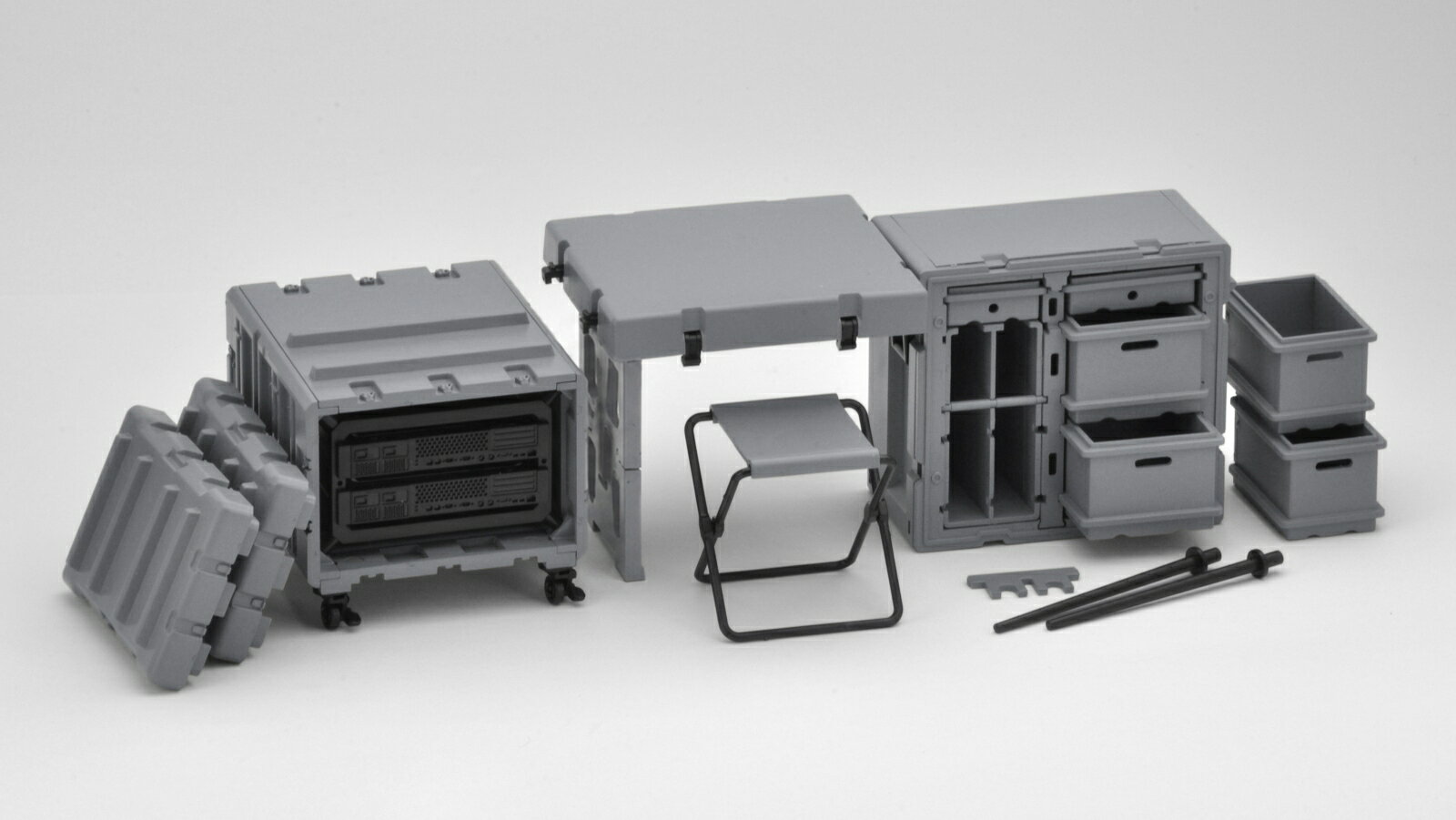 前線作戦基地・指揮所で使用されるコンテナ式デスク＆サーバーセットです。戦場で迅速に展開できるよう、強化樹脂製のコンテナそのものが机へと変形する軍用の事務机となります。
本キットは、その武骨な外見のみならず、変形機構も再現しており、コンテナからデスク状態への変形も楽しめます。キャビネットは、パーツ選択で一部を小型のガンラックにすることも可能。サーバーラックからサーバー本体を抜き取って使用することも可能です。今回は、成型色“グレー”バージョンとなります。

製品仕様
・1/12 プラモデル

ー

・ホビー系商品についての諸注意
メーカー都合により発売の大幅な延期が発生する可能性がございます。
予約商品についてはメーカーから順次入荷次第の発送となります。メーカー公表の発売日とは異なる場合がございますのでご了承ください。【対象年齢】：15歳以上