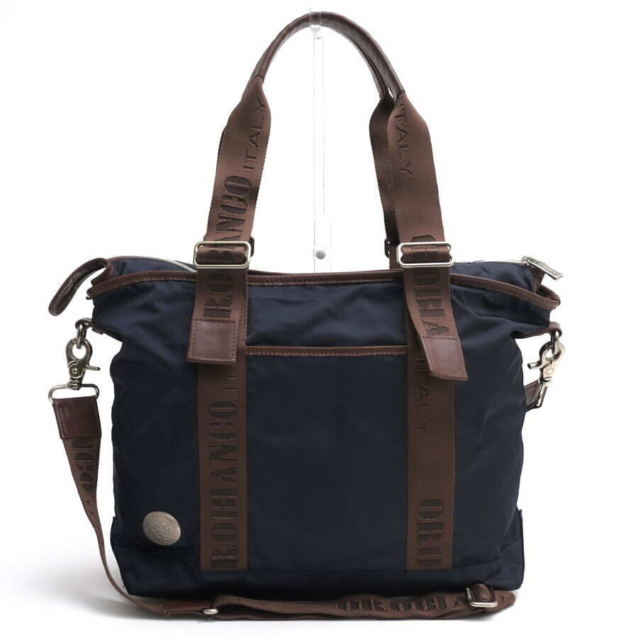 BRANDINGの全商品で利用可↓↓1%OFFクーポン↓↓orobianco オロビアンコ トートバッグ メンズ BELLACIAO-Z7 伊リモンタ社ナイロン 牛革商品説明「Orobianco」はイタリア、ガラレーテを拠点とする1996年ジャコモ・バレンティーニによって創立され、世界各国のバイヤーより支持されている、BAGを中心とするブランド。各アイテムのアイデアは、旅や日々の生活経験から生まれており構造的、機能的にも優れています。またオロビアンコはファッション業界の中にあって、イタリア熟練工やその職人技を前面に打ち出し「made inItaly」の強みを生かした物作りを継続するブランドです。イタリアンテイストにあふれたデザインとクオリティーの高いモノづくりで、老若男女問わず愛されています。メイン素材に耐久性と軽さを兼ね備えたナイロンを採用し、随所にイタリアンレザーをあしらった上品なトートバッグ。天マチにはファスナーが施されており、横向きにしても荷物がこぼれない構造は、セキュリティ面での安心感を高めています。内部は小分け収納に優れたファスナーポケット、携帯ポケット、ミニポケットを完備し、日常使いからビジネス、短期旅行まで幅広く活躍。ハンドルは長さ調整が可能で、スタイルやシーンに応じた柔軟な使い分けが可能です。商品詳細◆ブランド名　orobianco◆サイズ詳細　横幅 約34cm、縦幅 約30cm、マチ 約12.5cm◆仕様　ファスナー開閉 前面ポケット×1 内側ファスナーポケット×1、ミニポケット×1、携帯用ポケット×1◆特徴　2WAY ショルダーバッグ ユニセックス 男女兼用◆型番　BELLACIAO-Z7◆生産国　イタリア◆素材　上質なナイロン×革レザー◆素材詳細　伊リモンタ社ナイロン × 牛革◆色　ネイビー 紺◆商品状態　中古品-良い◆付属品　ショルダーストラップ、保存袋◆備考　NYLON-BLU-SCURO-12 VIT-CASTAGNA-09