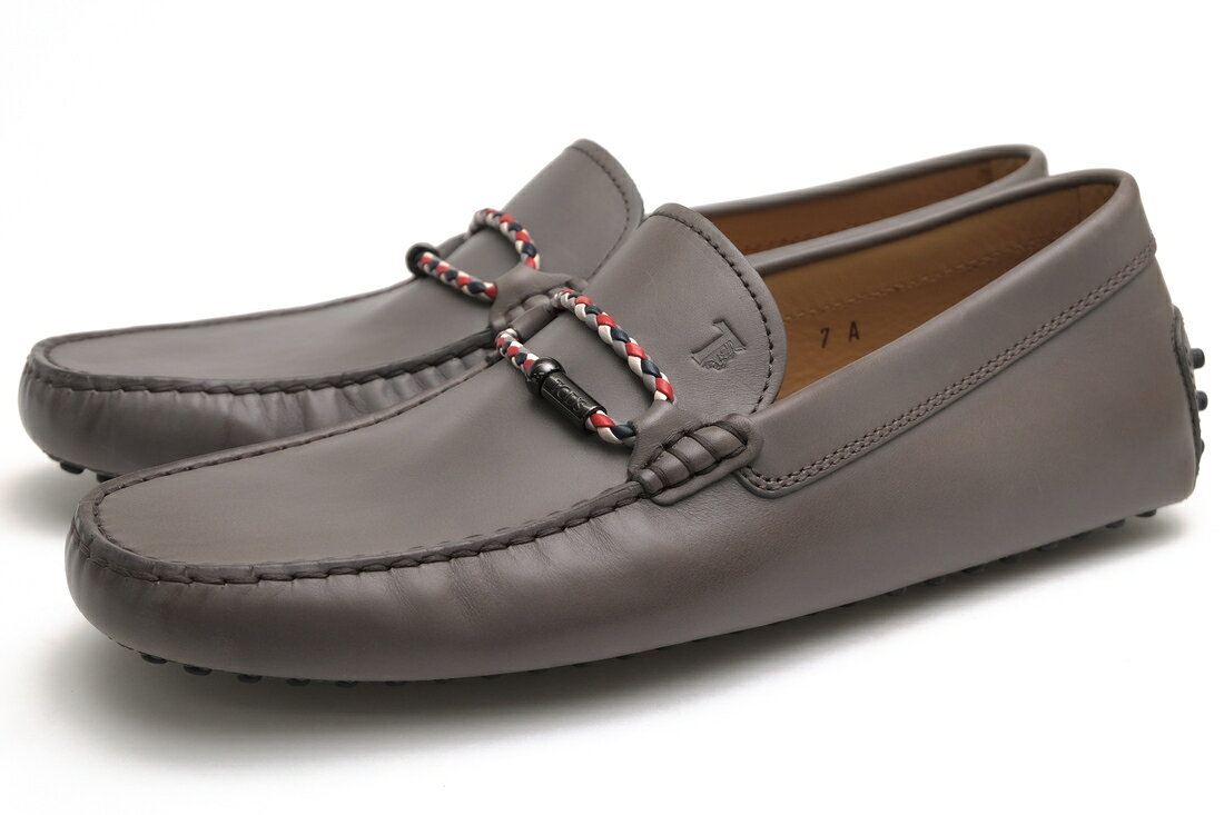 BRANDINGの全商品で利用可↓↓1%OFFクーポン↓↓TOD'S / トッズTOD'S トッズ ドライビングシューズ XXM0GW0L910D9ZU817 MORSETTO CLUB NEW GOMMINI ゴンミーニ カーフレザー 牛革商品説明上質な素材に定評がある、イタリア発のセレブ御用達ブランド、トッズ。1920代イタリア創業の老舗は、これまでにドライビングシューズ「ゴンミーノ・モカシン」をはじめとした数々の定番商品を生み出し、イタリアならではの伝統の製法や素材へのこだわりは現在でも受け継がれ、世界有数のレザーグッズブランドとして君臨しつづけています。厳選された最高のレザー、伝統の職人技、そして洗練されたモダンなデザインを極めてきました。ブランドを象徴するラバーペブルソールを備えたドライビングシューズ「MORSETTO CLUB NEW GOMMINI」。1978年に誕生したトッズの代表作「ゴンミーニ」は、当時主流だった重く硬い紳士靴の常識を見直す中で、構想。ニューヨーク旅行をきっかけに、運転用シューズを日常でも履ける靴へ再設計したことから生まれたモデルです。最大の特徴は、アウトソールに配されたラバースタッズ。足裏からヒールにかけて連続して打ち込まれ、ペダル操作時のグリップを確保すると同時に、屈曲性と軽快な履き心地を実現しています。甲部にはトッズの定番ディテールであるモルセット金具を配置。軽量で携行しやすく、旅行やリゾートシーンにも適した一足。ドライビング用途だけでなく、街履き用ローファーとしてもオススメです。商品詳細◆ブランド名　TOD'S◆サイズ表記　UK7◆日本サイズ参考　約25.5-26.0cm◆サイズ詳細　アウトソール靴底全長 約27.5cm、アウトソール靴底幅 約10cm、ヒール高さ 約0.5cm◆特徴　ローファー型 スリッポン 定番◆型番　XXM0GW0L910D9ZU817 MORSETTO CLUB NEW GOMMINI ゴンミーニ◆生産国　イタリア◆素材　上質な革 レザー◆素材詳細　カーフレザー（牛革）◆色　グレー 灰色◆商品状態　中古品-非常に良い◆状態詳細　美品◆付属品　保存袋