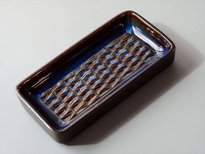 希少な北欧ミッドセンチュリー期の名作！デンマーク名窯Soholmのスクエアトレーです。同窯で多くの作品を手がけたEinar Johansenによって手がけられました。ネイビーにわずかなブラウンを差した色合いが美しく連なるトライアングルも氏を代表するデザインです。商品自体のもつ風格が非常に高いため器そのものを飾るだけでも十分、絵になります。サイズ(cm)状態18.5 x 9.4高さ 3.2若干の誤差はご了承くださいUSED目立つ汚れやダメージはありません。素材原産国ストーンウェアデンマーク【送料無料】デンマーク製 Soholm スクエアプレート 18x9cm トレー スーホルム Einar Johansen 北欧 アンティーク ヴィンテージ_260225希少な北欧ミッドセンチュリー期の名作！デンマーク名窯Soholmのスクエアトレーです。同窯で多くの作品を手がけたEinar Johansenによって手がけられました。ネイビーにわずかなブラウンを差した色合いが美しく連なるトライアングルも氏を代表するデザインです。商品自体のもつ風格が非常に高いため器そのものを飾るだけでも十分、絵になります。サイズ・実寸値(cm)18.5 x 9.4高さ 3.2若干の誤差はご了承ください素材ストーンウェア原産国デンマーク状態・注意点USED目立つ汚れやダメージはありません。備考お店のトップに戻る