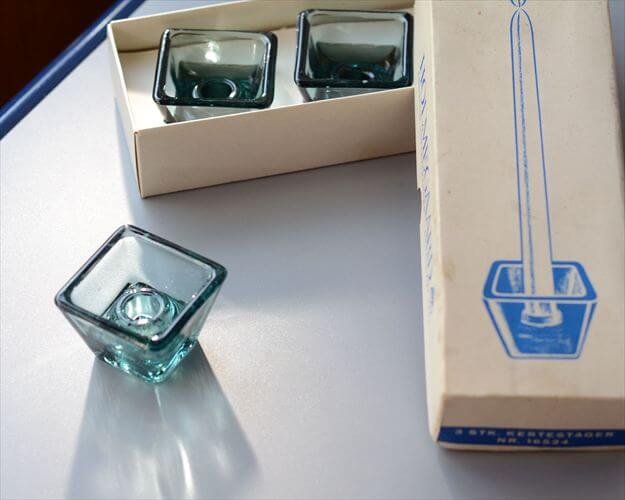 希少なホルムガードの箱付きヴィンテージ！デンマークの名門Holmegaard、ガラスのキャンドルスティック3個セット・箱付きです。北欧を代表するガラスメーカーの一つだけあってクリアで肉厚なマリンブルーグラスの美しさに目を奪われます。1960-70年代頃のものと思われるオリジナルボックスもレトロなディスプレイです。火を灯したローソクのゆらめきと、ほのかに映し出されるガラス表情とのコントラストが癒しの時間をもたらしてくれます。北欧やヨーロッパでは身近なインテリアとして愛されているキャンドルツール、是非日常に取り入れて豊かな時間をお過ごしください。サイズ(cm)状態5.1 x 5.1中央径 1.8高さ 3.8USED使用感ございますが目立つ汚れやダメージはありません。素材原産国ガラスデンマーク一部商品において実店舗と在庫を共有しておりますのでご注文完了後に【当店からの】ご案内メールをもちまして在庫確保となります。※楽天市場からの「注文内容ご確認（自動配信メール）」ではありません。もし事前に在庫確保/ご確認を希望される場合は「ショップへ相談」フォームよりお気軽に問い合わせくださいませ。【送料無料】デンマーク製 Holmegaard キャンドルスティック 3個セット 箱付き ホルムガード ホルダー 北欧 ガラス 燭台 アンティーク_251111希少なホルムガードの箱付きヴィンテージ！デンマークの名門Holmegaard、ガラスのキャンドルスティック3個セット・箱付きです。北欧を代表するガラスメーカーの一つだけあってクリアで肉厚なマリンブルーグラスの美しさに目を奪われます。1960-70年代頃のものと思われるオリジナルボックスもレトロなディスプレイです。火を灯したローソクのゆらめきと、ほのかに映し出されるガラス表情とのコントラストが癒しの時間をもたらしてくれます。北欧やヨーロッパでは身近なインテリアとして愛されているキャンドルツール、是非日常に取り入れて豊かな時間をお過ごしください。サイズ・実寸値(cm)5.1 x 5.1中央径 1.8高さ 3.8素材ガラス原産国デンマーク状態・注意点USED使用感ございますが目立つ汚れやダメージはありません。備考お店のトップに戻る