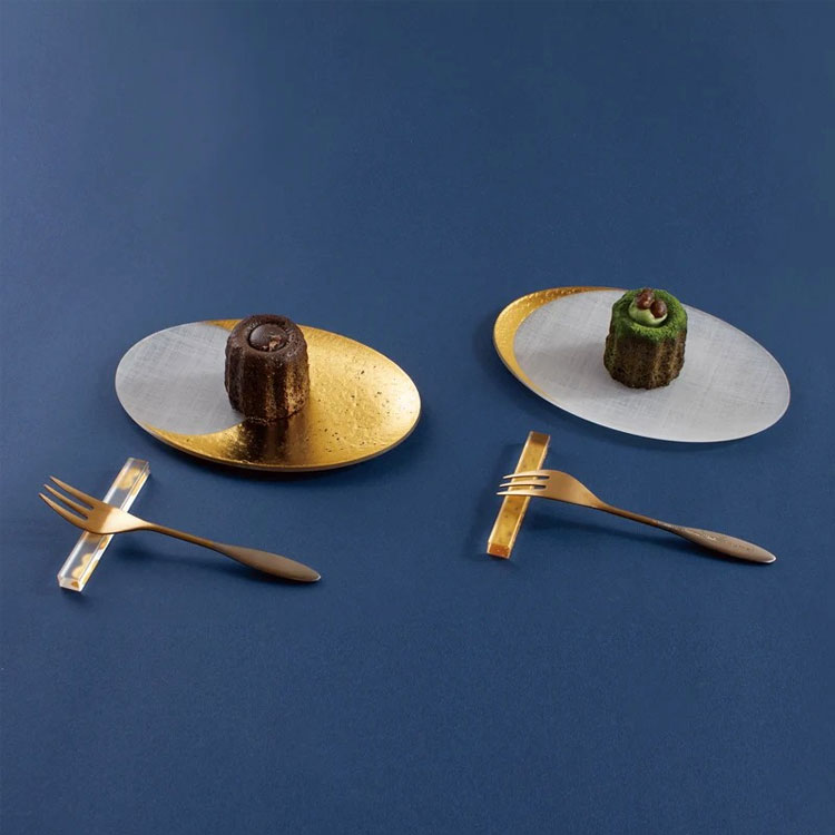 箔 coval 15.5cmに箔カトラリーと箔カトラリーレストのペアギフトセットです。上品な箔のデザインが食卓を華やかに彩り、月の満ち欠けを思わせる美しい佇まいがゆったりとした食事の時間を演出します。大切な方への贈り物にもおすすめです。【サイズ】カトラリー：約13cm（A）／約14.5cm（B）coval：約幅15.5cm×奥行10.5cm×高さ0.8cmカトラリーレスト：約幅1cm×奥行7.5cm×高さ0.8cm【重量】カトラリー：約16g（A）／約18g（B）coval：約33gカトラリーレスト：約7g【素材】カトラリー：ステンレススチール18-8または18-10（マット仕上げ）、24K金メッキコーティングcoval・カトラリーレスト：アクリル樹脂、箔【耐熱】80℃（アクリル製品）カトラリー：食洗機の使用はお控えください。coval／カトラリーレスト：電子レンジ・オーブン・食洗機使用不可。高濃度アルコール、塩素系漂白剤はひび割れや箔の変色が発生する場合がございます。中性洗剤を薄めたもの、次亜塩素酸水の希釈液で行う事をお勧めいたします。