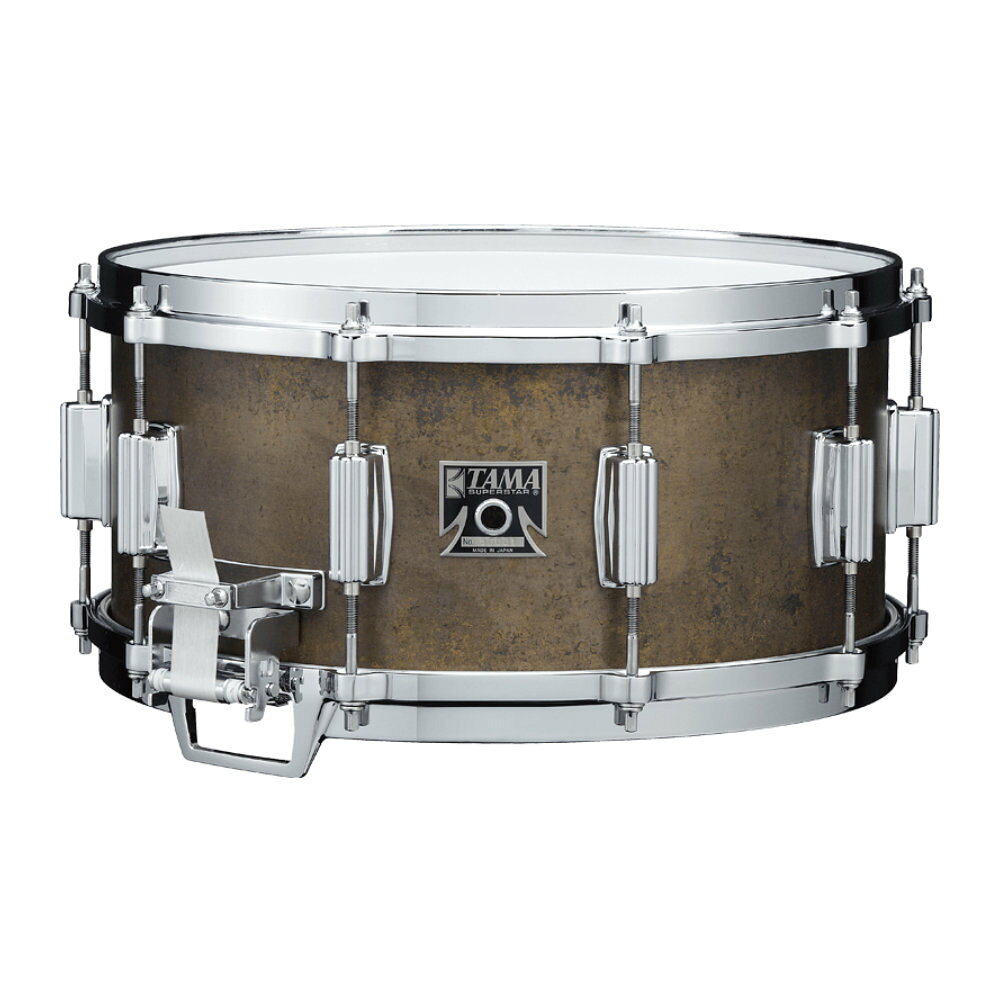 TAMA タマ BB-156 MASTERCRAFT "THE BELL BRASS" SNARE DRUM スネアドラム1980〜1990年代を象徴するロックアルバムに多く使用され、今でも一部のサウンドエンジニアの間で"TERMINATOR"と呼ばれるほど比類なき存在感を誇るスネアドラム、"Bell Brass"。鋳造後、3mm厚に削り出して成型したキャストベルブラスシェルを採用。この超重量級シェルによって得られる、耳をつんざくような圧倒的音圧と低音から高音まで幅広い音域をカバーするレンジの広さは他の追随を許しません。とりわけこの復刻モデルではシェルの外径を通常よりも2mm大きい355mmに設定したことに加え、ラグやストレイナーそしてスナッピーテープなどパーツ類をも徹底的に当時のモデルを再現。ベルブラススネアという名前を聞いた時に誰もが思い起こす”あのサウンド”を実現しました。時代を超えて愛されるその理由をぜひ体感してください。※レギュラーモデル【FEATURES】・355mm diameter, 3mm Bell Brass Shell鋳造後、3mm厚に削り出して成型したキャストベルブラスシェルを採用。爆発的な音圧にも関わらず、どんな音楽にも調和するレンジの広いサウンドは、今でも多くのドラマーを魅了しています。シェルの外径は一般的な14”モデルよりも敢えて2mm大きい355mmというオリジナルモデルのサイズを採用し、往年のサウンドを再現。また、シェルフィニッシュもオリジナルモデルを彷彿とさせる仕上げとしました。・Die-Cast Hoops (10 hole)80年代初期では一般的でなかった10穴のDie-Cast Hoopですが、アタックが明瞭で音抜けが良いサウンドを得るため、全てのMastercraftシリーズに適用されました。スネアサイドフープは、全面当たりスネアワイヤーが床に接するのを防ぐ窓付き形状を復刻しました。・18-strand Carbon Steel Long Snare Wires (6035N)当時の仕様をそのまま再現した、全面当たり方式の18本線カーボンスティールスネアワイヤーとフィラメントテープを採用。内面当たり方式と比較して、スネアワイヤーのみが裏面ヘッドに接するため、よりセンシティブな反応が得られます。・Roller Action Strainer全面当たりスネアワイヤーの微細な音色表現とボリューム感のあるバズ音を実現しながら、シンプルな設計で操作性を向上させた画期的なストレイナーです。ポイントは3mmの幅で上下に動くガイドローラーと、その動きを補助する小さなスプリング。スネアワイヤーの落差を大きくすることが可能になるとともに、スプリングの反発力を利用してガイドローラーがヘッドから確実に離れるようにしています。これにより、ストレイナーのオン/オフ切り替えが容易になり、そのシンプルな構造は多大な注目を集めました。一度生産が終了したこのストレイナーを、今回のモデルで忠実に復刻。その特有の音色と操作性を再び体験できます。・One-Touch Tone ControlオリジナルのMastercraftスネア用に開発されたインサイドマフラー。Mastercraftの発売当時はまだ録音技術も発展しておらず、ドラム自体のサウンドコントロールが重要だったため、多くのドラムに採用されていました。とりわけこのOne Touch Tone Controlは、微妙なミュート量の調整とワンタッチでのオン/オフの切り替えが可能だったことで、非常に画期的なアイデアとして高い評価を受けました。演奏中にも瞬時にサウンドを切り替えることができるこの機構は、録音技術が発達した現代でも、新たなサウンドの可能性を広げてくれます。・REMO AMBASSADOR Drumheads当時のロゴマーク印刷を復刻したREMO AMBASSADOR Coated Batter/ Snare Sideを採用しました。[Specifications]Model No：BB-156Shell：3mm Bell BrassSize：14"x6.5"Lug：Original Superstar Lug (6371N)Hoop：Die-Cast Hoop (10 hole)Strainer/Butt：Roller Action (6302N/6303N+6338N)Snare Wire：18-strand Carbon Steel Long Snare Wires (6035N)Inside Muffler：One-Touch Tone Control (6552N)Head：REMO Ambassador Coated TAMA 50th Anniversary version