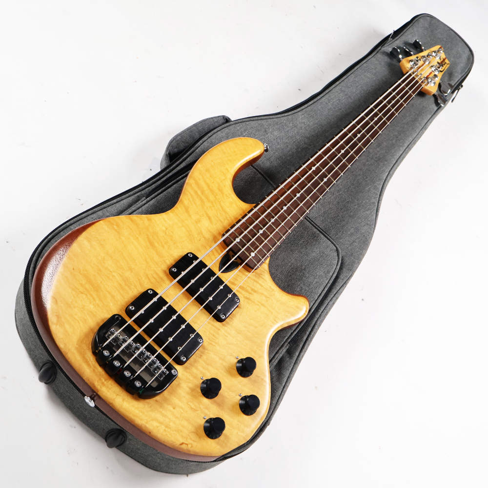 【中古】Wal ウォル MK2 5-String 1995年製 5弦エレキベースWal MK2 5-String 1995年製 の中古品です。中古なりのコンディションです。商品内容：本体・非純正ギグケース傷、打痕が散見されるコンディションです。ブリッジのネジが1個欠品しています。バックパネルのネジが4個欠品しています。フレットはすり合わせがされていると思われ、目立つような凹みも無く4割程度。トラスロッドは調整の余裕ありです。MADE IN ENGLAND重量：5.10kgナット幅：約46.3mm大変珍しいWalの5弦ベース MK2 5-String 1995年製です。マホガニーのコアにトップとバックに美しいフレイムメイプルを使用したボディ、メイプルとおそらくマホガニーと思われる5pcネック。指板材はローズウッドを採用しています。ボルトオン仕様。オリジナルのハムバッカーピックアップを2基とオリジナルのアクティブプリアンプを搭載しています。このプリアンプが独特な仕様で、基本的にはマスターボリューム、PUバランサー、2トーンとなっています。まず、マスター・ボリューム・コントロールは、出力音量をスムーズに調整できるだけでなく、プッシュ／プル機能により「ピック・アタック・モード」を作動させることができます。このモードでは、全体のトーン設定に特定の高域成分が加わり、ダイナミックでパーカッシブなアタック感が得られます。全体の出力レベルとピック・アタックのレベルは、いずれも内部で微調整（トリム）可能です。また、この各ピックアップに個別に設けられたトーン・ノブが、電子ローパス・フィルターとして動作します。このフィルターのロールオフ周波数は、コントロールの位置に応じて変化し、ノブを時計回りにいっぱいに回した状態（「10」の位置）では、フラットで豊かな周波数特性が得られ、ノブを戻していくと、該当するピックアップの周波数帯域が制限されていきます。そして、ノブを引き上げると、ロータリー位置で設定されたロールオフ周波数付近の倍音成分に対し、約10dBの準パラメトリック・ブーストがかかります。ピックアップ・コントロールとパン・ミキサー（マスター・トーンのように使用可能）を組み合わせることで、繊細なトーンからダイナミックな効果まで、幅広い音作りが可能になります。walならでは幅広いサウンドメイクと太くて温かみのあるサウンド。なかなかお目にかかれないブランドのベースでしかも5弦仕様！かなりレアな1本です。