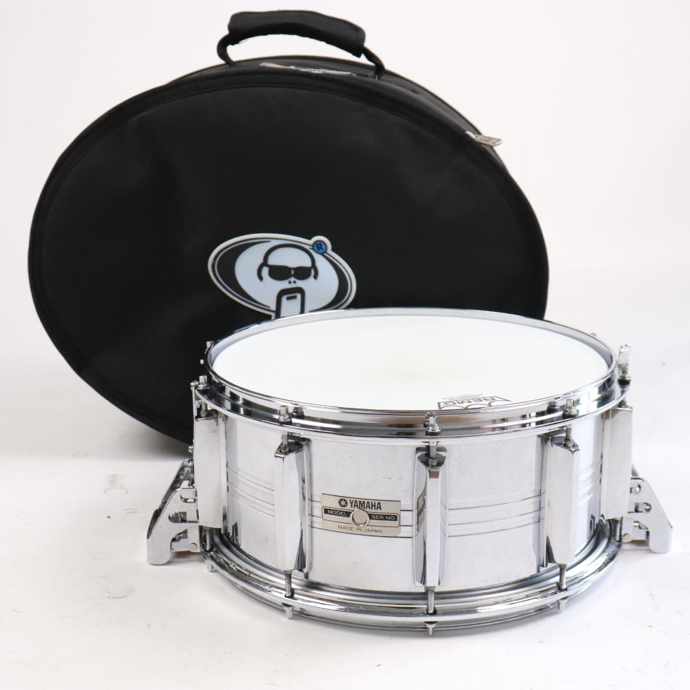 【中古】 スネアドラム ヤマハ YAMAHA SD-065M 14x6.5 Made in JapanYAMAHA SD-065M 14x6.5 Made in Japan の中古品です。使用感のあるコンディションです。商品内容：本体・キャリングケース（プロテクションラケット製）シェルやラグ、ストレイナー部にビッツ（点状のメッキの浮き）があります。ストレイナー部にメッキ剥がれや錆があります。全体的に小傷や汚れがあり、使用感のあるコンディションです。付属のプロテクションラケット製ケースから若干の生活臭がします。またサイズはスネアドラムよりやや大きめサイズとなります。コージー・パウエルの愛機としても有名なヤマハ製スチールシェルスネアドラム SD-065Mです。シェルはシームレス スチールシェルを採用し、スナッピー全面当たりのパラレル・アクション・ストレイナーを搭載。リムは切削リムとなっており、タイトで鋭く抜けのあるアタック感が特徴。パワフルな音量も魅力のスネアドラムです。Made in Japan 日本製サイズ：14×6.5シェル：シームレス スチールテンション：10テンション