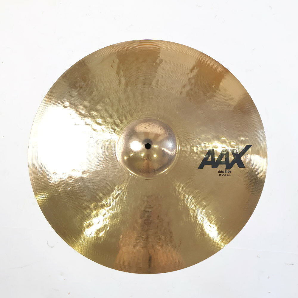 【中古】 SABIAN セイビアン AAX-21TR-B AAX THIN RIDE 21インチ ライドシンバル中古なりのコンディションです。商品内容：本体のみシンバル本体に割れやゆがみはございません。シンバル取り付け穴は正常です。傷や汚れがあり。■重量：約2310g大きく丸みのあるピーンはAAXラインの中では最も直線的でダークな効果をもたらす。さらにより高い音域も網羅されたワイドレンジなサウンドが魅力。AAXModern × BrightB20 BRONZECAST BRONZE80%Copper + 20%Tin + Trace of Silver ブライトでクイックレスポンス。大きめの”ハンドガイド”マシンハンマリングと、浅く高密度のレイジング加工によって、いかなるボリュームでもシンバル本来の音色を失うことなく、不要な倍音をカットした、ピュアで明確なサウンドが持ち味。サイズ：21インチウェイト：Thin