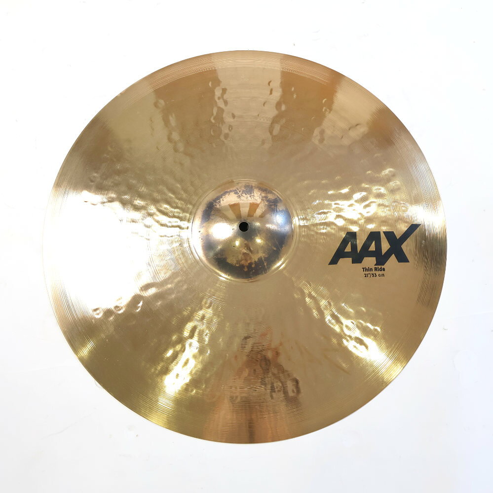 【中古】 SABIAN セイビアン AAX-21TR-B AAX THIN RIDE 21インチ ライドシンバル中古なりのコンディションです。商品内容：本体のみシンバル本体に割れやゆがみはございません。シンバル取り付け穴は正常です。傷や汚れがあり。■重量：約2290g大きく丸みのあるピーンはAAXラインの中では最も直線的でダークな効果をもたらす。さらにより高い音域も網羅されたワイドレンジなサウンドが魅力。AAXModern × BrightB20 BRONZECAST BRONZE80%Copper + 20%Tin + Trace of Silver ブライトでクイックレスポンス。大きめの”ハンドガイド”マシンハンマリングと、浅く高密度のレイジング加工によって、いかなるボリュームでもシンバル本来の音色を失うことなく、不要な倍音をカットした、ピュアで明確なサウンドが持ち味。サイズ：21インチウェイト：Thin