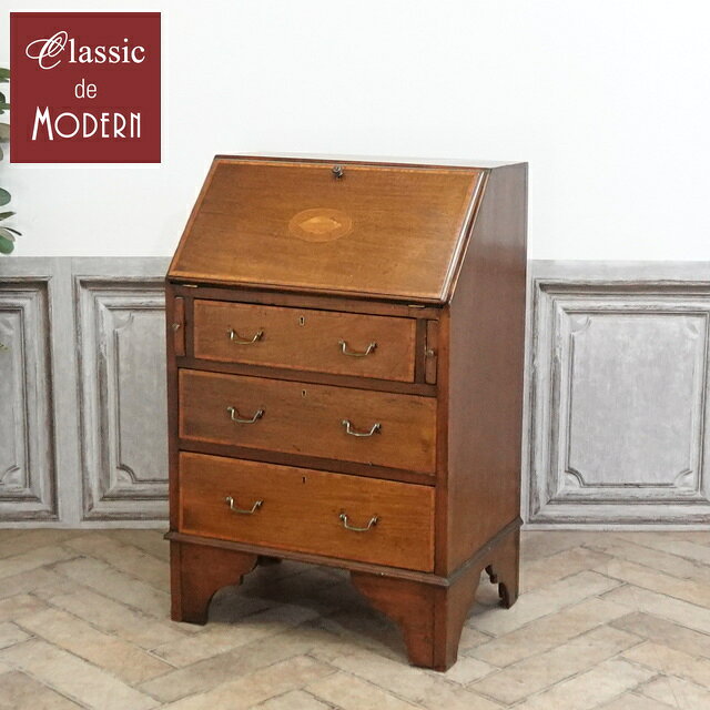 品名・品番 antique81275　ライティングビューロー　1910年頃　マホガニー材　イギリス サイズ W 62 x D 41 (拡張時 69) x H 93 (デスク高 66) cm 商品について マホガニー材の美しい杢目が目を惹く、ライティングビューローです。 デスク扉の中央には優雅なインレイがあしらわれ、 すっきりとしたデザインの中に、英国伝統の洗練された気品が漂います。 デスク扉を開くと、細かく仕切られた棚や小さな引き出しが現れます。 手紙を書いたり、読書やお裁縫などの趣味を楽しんだりと、 自分だけの落ち着いた時間を過ごすためのスペースとしてお使いいただけます。 使わないときはデスク扉を閉じるだけで、生活感をすっきりと隠せるのも魅力です。 下部には3段の引き出しを備え、衣類や小物などを収納するチェストとしても活躍します。 ご自宅だけでなくショップ様の店舗什器としてもおすすめです。 時を経たものの不思議な存在感は、本物でしか味わえない魅力ですよ♪ 所々にハリの剥がれ・デスク天板にひび割れ・蝶番の周りにひび割れ補修跡がございます。 こちらのアイテムは・・・ 『本物』アンティーク家具につき、在庫は1点限り 次回再入荷がないのがアンティーク家具。 お気に入りのものが見つかったら、お早めにご検討下さい 配送について 配送:家財便 Cランク 配送方法については、こちらをご参照ください。 ご注意ください 在庫数は随時チェックしておりますが、他サイトでの販売も行っておりますので 売約在庫切れになる場合がございます。あらかじめご了承ください。 送料は買い物かご合計時に0円となりますが、弊社では大小さまざまな商品を扱っております。 ご注文メール確認後に送料を含めたご注文明細をご案内いたします。 ※離島につきましては、配送可能かをご注文前にお問い合わせくださいませ。 お問い合わせ先 クラシックデモダン 電話：0748-64-9027　FAX：0748-83-1184 メール：store@classicdemodern.com