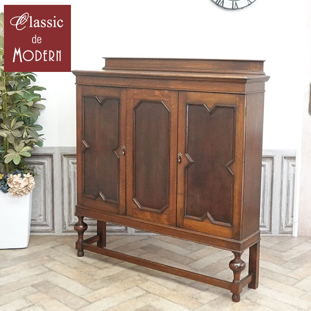 品名・品番 antique81078　ブックケース　1920年頃　オーク材　イギリス サイズ W 123 x D 31 x H 131 (天板高 123) cm 商品について 落ち着いたデザインのブックケースです。 弊社で扱っているブックケースはガラス扉のものが多いのですが、 こちらは全面が美しい木製扉で仕上げられた珍しいデザイン！ 扉の幾何学的なデザインが特徴的で、味わい深い雰囲気は、本物アンティークだからこそですよね。 色とりどりの書籍や、生活感の出やすい書類、ファイルなどをたっぷりと収納しても、 扉を閉めれば一瞬で格調高い空間へと早変わりします。 また、ガラスが割れる心配がないという安心感はウッド扉ならではの嬉しいポイントです。 本棚としてはもちろん、リビングのサイドボードや、食器やリネンを収める収納棚としてもマルチに活躍。 生活感を美しく隠す贅沢な暮らしを始めてみませんか。 扉に反りがございます。 こちらのアイテムは・・・ 『本物』アンティーク家具につき、在庫は1点限り 次回再入荷がないのがアンティーク家具。 お気に入りのものが見つかったら、お早めにご検討下さい 配送について 配送:家財便 Dランク 配送方法については、こちらをご参照ください。 ご注意ください 在庫数は随時チェックしておりますが、他サイトでの販売も行っておりますので 売約在庫切れになる場合がございます。あらかじめご了承ください。 送料は買い物かご合計時に0円となりますが、弊社では大小さまざまな商品を扱っております。 ご注文メール確認後に送料を含めたご注文明細をご案内いたします。 ※離島につきましては、配送可能かをご注文前にお問い合わせくださいませ。 お問い合わせ先 クラシックデモダン 電話：0748-64-9027　FAX：0748-83-1184 メール：store@classicdemodern.com