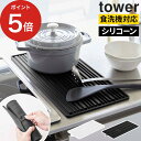 くるくるシリコーンドライマット タワー 無駄を省いたデザインが人気の、towerシリーズの水切りマット。柔らかいシリコーン製なので濡れた食器やカトラリーを置いても滑りにくく、傷つけません。使わないときはくるくると巻いてコンパクトに収納可能。引き出しにもすっきり収まります。 熱に強く、鍋敷きとしても活躍する2WAY仕様。食洗機対応でお手入れが簡単なのも嬉しいポイントです。 通気性の良い溝でスムーズに食器を乾燥。突起部分は幅が異なり、大きな食器から小さなピックなどの小物まで幅広く対応しています。 くるくると巻いたマットを止めておく穴は、フックに掛けるときにも便利。洗ったマットを乾かしたり、吊り下げて収納することも可能です。 【p5】 水切りマット 食洗機対応 洗える 水切り マット 北欧 シリコン 耐熱 シリコンマット ドライングマット ドライマット 一時置き 鍋敷き キッチン 流し台 タワーシリーズ シンプル 山崎実業 tower yamazaki ブラック ホワイト 調理器具 コンロ回り シンク回り シリコーン 吊り下げ収納 浮かせる収納 丸めて収納 コンパクト スリム towerシリーズ 一人暮らし 新生活 白 黒 北欧 モダン 5700 5701 おしゃれくるくるシリコーンドライマット タワー (洗える 水切りマット 食洗機対応 tower) DETAIL 商品名 くるくるシリコーンドライマット タワー 品番 / JAN ホワイト：5700 / 4903208057004 ブラック：5701 / 4903208057011 サイズ [ 使用時 ] 約 横幅44.2cm × 奥行き21.8cm × 高さ0.6cm 引っ掛け穴込みの横幅：約 47.2cm [ 収納時 ] 約 横幅21.8cm × 奥行き7.5cm × 高さ7.5cm 耐熱温度 230℃ 耐冷温度 -40℃ 材質 シリコーン 製造国 中国 備考 食器洗い乾燥機対応 ※ 直火・グリル・オーブンレンジ・オーブントースター・電子レンジ・業務用食器洗い乾燥機でのご使用はお止めください。 ※ 熱いものを置いて使用する際は、塩化ビニール製な等の耐熱温度の低い板やテーブルクロスの上では使用しないでください。 無駄を省いたデザインが人気の、towerシリーズの水切りマット。柔らかいシリコーン製なので濡れた食器やカトラリーを置いても滑りにくく、傷つけません。使わないときはくるくると巻いてコンパクトに収納可能。引き出しにもすっきり収まります。 熱に強く、鍋敷きとしても活躍する2WAY仕様。食洗機対応でお手入れが簡単なのも嬉しいポイントです。 通気性の良い溝でスムーズに食器を乾燥。突起部分は幅が異なり、大きな食器から小さなピックなどの小物まで幅広く対応しています。 くるくると巻いたマットを止めておく穴は、フックに掛けるときにも便利。洗ったマットを乾かしたり、吊り下げて収納することも可能です。 山崎実業特集 はこちら キッチン雑貨 ランキング