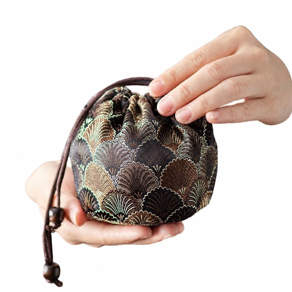 　　　 ◆◇◆売れている秘密◆◇◆ 【上品な和風デザイン】美しい刺繍が施された茶器収納袋は、光沢感のあるジャガード織風の生地を採用し、溢れる仕上がりです。落ち着いたオリエンタル柄の茶器ポーチは、持っているだけでお茶の時間を優雅に演出します。手触りも滑らかで、大人のライフスタイルに寄り添う美しい和モダンな巾着袋です。 【優れた保護機能】クッション性に優れた内綿入りの茶杯ポーチが、大切な茶碗や茶壺を衝撃から守ります。厚みのあるソフトな生地のトラベル茶具入れなので、移動中の傷や破損を防ぎ、繊細な陶磁器やガラス製の耐熱茶器も安心して持ち運べます。旅行やアウトドアでの大切な茶器の保管に最適な携帯用茶器袋です。 【持ち運びに便利な巾着仕様】紐を引くだけで開閉できる巾着タイプの旅行用茶器ケースです。コンパクトな茶道具収納バッグは、リュックにすっきりと収まり場所を取りません。旅行や出張、キャンプなどのアウトドアシーンでも、この携帯用茶器入れがあれば、お気に入りのお茶セットをいつでも手軽に楽しめます。 【丁寧な縫製と高耐久性】細部まで丁寧に縫製された頑丈な小物入れ巾着は、型崩れしにくく長く愛用いただけます。開口部の紐には上品な木製ビーズがあしらわれ、スムーズな開閉を実現しました。汚れても手洗い可能な布製収納袋なので、アウトドアで使用した後もお手入れが簡単で常に清潔に保てます。 【ギフトにも最適な万能サイズ】シングルカップや小型茶器の収納はもちろん、アクセサリーやコスメを入れる小物ポーチとしても大活躍します。お茶が好きな方へのプレゼントや、特別な日の贈り物にも喜ばれる逸品です。実用性とデザイン性を兼ね備えた上品なミニ巾着袋を、日常の様々なシーンでご活用ください。 　　　◆◇◆注意事項◆◇◆ご覧のモニターの環境、撮影環境により実物と色味が異なって見える場合がございます。湿った状態で他のものと擦り合わせると色が移る恐れがあります。濃色品の洗濯時は、白色、淡色と分けて洗ってください。説明 【美しい伝統柄と上質な質感】金襴織物のような上品な光沢感と精巧な刺繍パターンが特徴の**巾着袋 和柄**です。手に取るたびに温かみを感じる美しい和風デザインで、お気に入りのマイカップを優雅に包み込みます。落ち着いた色合いは日常使いだけでなく、お出かけ先でも持ち歩く楽しさを演出します。 【大切な茶器を保護する厚手設計】この**茶器 収納袋**は、クッション性のある厚手の裏地を採用しており、移動中の衝撃や摩擦から繊細な陶磁器を守ります。お気に入りの**湯呑み 収納バッグ**として、また蓋碗や小さな急須を入れるケースとして、大切な茶器が傷つくのを防ぎ、安心して持ち運ぶことができます。 【便利な巾着式で出し入れもスムーズ】サッと紐を引くだけで簡単に開閉できるドローストリング仕様の**ポータブル 茶器入れ**です。出し入れが非常にスムーズで、旅先でもスマートにお茶の時間を始められます。旅行や出張、ピクニック、アウトドアでのティータイムに最適な**旅行用 茶具ケース**です。 【丁寧な縫製と耐久性のある仕上がり】細部まで丁寧に縫製された**茶碗 ポーチ**は、繰り返し使用しても型崩れしにくく、長くご愛用いただけます。軽量でありながら丈夫な素材を使用しており、汚れが気になった際のお手入れも簡単です。使い込むほどに手に馴染む質感で、お気に入りの茶器に寄り添います。 【お茶愛好家へのギフトにも最適】コンパクトなサイズ感で、個人のマイカップや煎茶碗、小さな急須などをスマートに収納できます。普段からお茶を嗜む方への実用的なプレゼントや、お正月、敬老の日などの贈り物としても大変喜ばれる**茶器 収納袋**です。実用性と美しさを兼ね備えた逸品です。