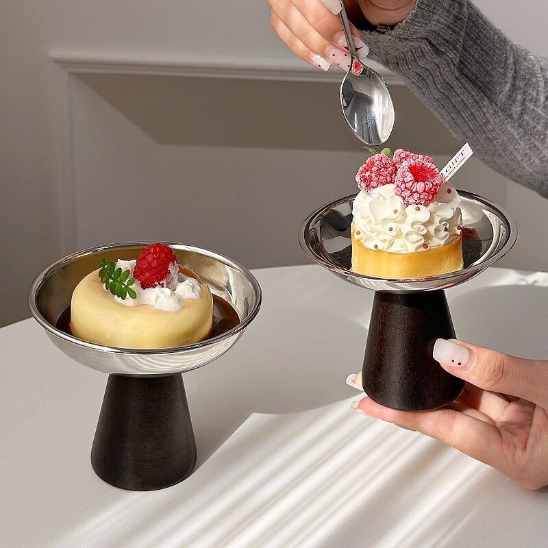 　　　 ◆◇◆売れている秘密◆◇◆ 【レトロでおしゃれなデザイン】温かみのある木製スタンドとスタイリッシュなステンレスを組み合わせたレトロ デザートカップです。北欧風やインス風のインテリアによく馴染み、いつものデザートタイムをカフェのような特別な時間へと演出します。上品な光沢のステンレス デザートカップはおもてなしにも最適です。 【冷たさをキープする機能性】熱伝導率の高いステンレス アイスカップは、ひんやりとした冷たさを長く保ちます。アイスクリームやシャーベットなどの冷たいスイーツが溶けにくく、最後まで美味しく味わえます。この実用的なステンレス アイスクリームカップで、贅沢なひとときをご堪能ください。 【持ちやすく安定感のある使い心地】手に馴染みやすい木製ベースを採用した高脚 デザートグラスです。ウッド素材の土台は滑りにくく、テーブルの上でも優れた安定感を発揮します。お子様から大人まで安心して使える木製 スタンド アイスカップで、おうちカフェ気分を毎日の暮らしの中で手軽に楽しんでいただけます。 【優れた耐久性とお手入れのしやすさ】サビに強く食品衛生にも配慮された304ステンレス プリンカップです。落としても割れる心配がないため、長く愛用できる耐久性を備えています。汚れが落ちやすくお手入れも簡単なステンレス デザートグラスは、日常使いとして忙しい毎日でも気兼ねなくご使用いただけます。 【幅広い用途でギフトにもおすすめ】プリンやゼリー、ミニケーキなど様々なスイーツに使える万能なレトロ プリンカップです。普段の食卓からホームパーティー、写真映えするおやつ作りまで幅広く活躍します。デザイン性と実用性を兼ね備えたおしゃれ シャーベットグラスは、新築祝いやプレゼントにも喜ばれる逸品です。 　　　◆◇◆注意事項◆◇◆ご覧のモニターの環境、撮影環境により実物と色味が異なって見える場合がございます。湿った状態で他のものと擦り合わせると色が移る恐れがあります。濃色品の洗濯時は、白色、淡色と分けて洗ってください。説明 【お洒落なレトロデザイン】な304ステンレスと温かみのある木製スタンドを組み合わせた、モダンなステンレス製デザートカップです。光沢のあるシルバーと落ち着いたダークブラウンの台座が、テーブルの上を華やかに演出します。写真映えするデザインで、おうちカフェ気分を贅沢に楽しめます。 【優れた保冷効果】冷たさをキープしやすい金属製のアイスクリームカップなので、ひんやりしたプリンやアイスを最後まで美味しく味わえます。熱伝導を抑える木製の脚付きデザートカップは、手で持っても体温が伝わりにくく、お気に入りの冷たいスイーツの食べ頃温度を保つ実用的な設計です。 【多彩なスイーツに対応】手作りプリンやパフェ、カットフルーツなど、様々なメニューを美しく引き立てるプリンカップです。いつものおやつを盛り付けるだけで、高級喫茶店のようなレトロで上品な一皿に早変わりします。来客時のおもてなしや、週末の特別なご褒美タイムに最適な食器です。 【耐久性が高くお手入れ簡単】錆びにくく頑丈な食品グレードの304ステンレスを使用しており、割れる心配がなく長く愛用できる高脚デザートグラスです。汚れがサッと落ちてお手入れが簡単なため、毎日気兼ねなく使えます。細部まで丁寧に仕上げられた品質の高さと、木製台座の安定感が魅力です。 【大切な方へのギフトにも】おうちカフェや写真映えが好きな方へのプレゼントにぴったりなレトロな食器です。持ちやすい高さと安定感のあるサイズ設計で、日常使いからホームパーティーまで幅広く活躍します。新築祝いや誕生日、大切な人へのちょっとした贈り物としてもセンスが光るアイテムです。