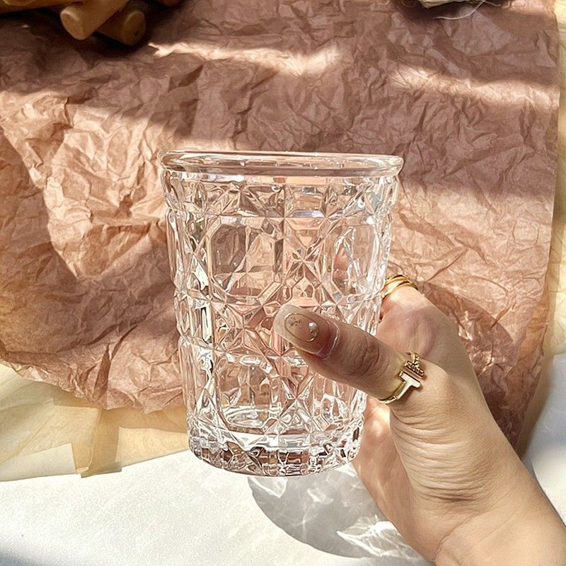 　　　 ◆◇◆売れている秘密◆◇◆ 【レトロで美しいデザイン】上品な光沢を放つこのクリスタルグラスは、職人の手で作られたような美しい格子模様のカットが特徴です。光があたるとキラキラと美しく輝き、いつものテーブルを華やかに彩ります。おうちで簡単におしゃれなカフェ気分を味わえる、デザイン性の高いガラスコップです。 【毎日の多様なシーンで活躍】このロックグラスは、ウイスキーやブランデーなどの洋酒はもちろん、毎日の冷茶やジュース用としても大活躍します。程よい厚みと重厚感があり、お酒の風味を引き立てるウイスキーグラスとして、一日の終わりに楽しむ特別なリラックスタイムを演出します。 【手になじむ快適な持ちやすさ】表面に施された立体的な凹凸カットのおかげで、このグラスコップは濡れた手で持っても滑りにくく、の持ちやすさを誇ります。口当たりの良い滑らかなフチ仕上げで、毎朝の牛乳カップや食後のお茶カップとしても心地よくお使いいただけます。 【優れた耐久性と高い透明感】光を美しく反射する頑丈なガラス素材を使用しているため、このタンブラーは傷がつきにくく、長く愛用いただけます。汚れも落としやすくお手入れが簡単です。日常使いの家庭用コップとして、上質なデザインと実用性を両立した使い勝手の良い逸品です。 【大切な方への特別なギフトに】あふれるモダンなデザインの焼酎グラスは、ご自宅用にはもちろん、引っ越し祝いや記念日、母の日や父の日のプレゼントにも最適です。世代を問わず愛されるおしゃれな洋酒カップで、大切な人へ日頃の感謝を伝える贈り物として自信を持っておすすめします。 　　　◆◇◆注意事項◆◇◆ご覧のモニターの環境、撮影環境により実物と色味が異なって見える場合がございます。湿った状態で他のものと擦り合わせると色が移る恐れがあります。濃色品の洗濯時は、白色、淡色と分けて洗ってください。説明 【美しいカットの輝き】光を美しく反射するレトロなデザインのグラスは、繊細な格子模様が施されたクリスタルガラスコップです。光が当たるたびにテーブルの上できらきらと輝き、日常の食卓にのある華やかさをプラスします。手に取るたびにその繊細な職人技と美しいカッティングの魅力に引き込まれる逸品です。 【多彩な飲み物に対応】お茶や牛乳だけでなく、洋酒やウィスキーなど様々なドリンクに使える万能なガラスコップです。程よい厚みと強度を備えた耐久性に優れたグラスは、急激な温度変化にも強く、冷たいドリンクから温かい飲み物まで一年中活躍します。透き通るような高い透明度が、飲み物の色彩をより引き立てます。 【心地よいホールド感】表面の立体的なカット加工が滑り止めの役割を果たし、濡れた手でも滑りにくく持ちやすいコップです。手のひらに心地よく収まるサイズ感のロックグラスは、毎日のリラックスタイムをより特別なものに変えてくれます。安定感のある広口設計で、氷も入れやすく、飲み口も滑らかに仕上げています。 【簡単お手入れと上質さ】日常使いに嬉しい、汚れが付きにくくお手入れしやすいコップです。底面まで手が届きやすい広口形状なので、隅々まできれいに洗うことができ、衛生的に保てます。傷がつきにくい頑丈な仕上がりで、毎日繰り返し使ってもクリアな輝きを失わない、美しさと実用性を兼ね備えたおしゃれなグラスです。 【贈り物にも最適】自分用にはもちろん、新築祝いや結婚祝い、誕生日などのギフトに最適なグラスです。年齢や性別を問わず愛される上品なデザインの家庭用ガラスコップは、日々のカフェタイムから特別な日のパーティーまで幅広く使えます。いつもの暮らしを格上げし、贅沢な空間を演出します。