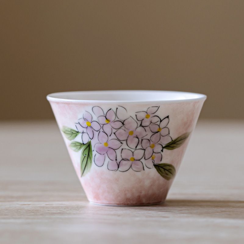 　　　 ◆◇◆売れている秘密◆◇◆ 【優雅な手描き花柄デザイン】職人の繊細な筆遣いによる木刺繍の花が咲き誇る、上品で可愛らしい陶器茶杯です。柔らかなグラデーションの淡い色彩が白磁の美しさを引き立て、テーブルを華やかに演出。日々のティータイムを心温まる特別な時間へと変えてくれる、高意匠な手描き茶器です。 【香りと味を引き立てる笠型フォルム】伝統的な斗笠杯の形状を採用し、お茶の豊かな香りが心地よく広がる設計です。広く開いた口縁部により、注いだ中国茶や緑茶、紅茶の美しい水色を目でも楽しめます。手のひらにしっとりと馴染む絶妙なサイズ感で、最後の一滴まで風味豊かに堪能できます。 【極上の口当たりと癒しの使用感】口元に沿う薄口仕上げで、飲み物の味わいをまろやかかつダイレクトに伝えます。自分専用の贅沢な主人杯として愛用でき、仕事の合間や食後のリラックスタイムに最適です。お気に入りの湯呑みでお茶を愉しむ、心豊かなライフスタイルを提案します。 【上質な磁器素材とお手入れの手軽さ】高温で丁寧に焼き上げられたな陶磁器は、表面が滑らかで汚れや茶渋が付きにくく、毎日のお手入れも簡単です。手描き絵付けの温かみと耐久性を両立し、普段使いの和食器としてはもちろん、大切なお客様をお迎えする来客用茶具としても活躍します。 【女性への贈り物や特別なギフトに】された美しさと実用性を兼ね備えたこの煎茶碗は、お茶を嗜む方へのプレゼントに大変喜ばれます。母の日や敬老の日、誕生日、新築祝いなど、感謝を伝えるギフトとして最適です。お酒を嗜むぐい呑みや酒器としても使え、幅広いシーンで重宝します。 　　　◆◇◆注意事項◆◇◆ご覧のモニターの環境、撮影環境により実物と色味が異なって見える場合がございます。湿った状態で他のものと擦り合わせると色が移る恐れがあります。濃色品の洗濯時は、白色、淡色と分けて洗ってください。説明 【手描き紫陽花デザイン】繊細な筆遣いで描かれた紫陽花が美しく咲き誇る陶器茶杯。やわらかなピンクのグラデーションと上品な絵付けが食卓を彩り、眺めているだけでも心が和みます。手仕事の温もりが感じられる、特別なひとときに寄り添う和食器です。 【香りを引き立てる笠型茶碗】優美に広がる斗笠杯フォルムが、煎茶や中国茶、ハーブティーの芳醇なアロマをふわりと広げます。唇に心地よくフィットする薄口のフチ設計で、お茶本来の繊細な風味と澄んだ水色を五感でじっくりと堪能していただけます。 【手になじむ優美なマイカップ】女性の手のひらにも優しく収まる絶妙なサイズ感の個人専用茶器。忙しい日々の合間のリラックスタイムや、丁寧にお茶を淹れるおうちカフェにぴったり。毎日のティータイムを、心ほどける優雅な時間へと演出します。 【滑らかで清潔に保てる陶器】上質な陶土を高温で丁寧に焼き上げた丈夫な湯呑み茶碗。内面はツルリとした質感で茶渋や汚れが付きにくく、使用後のお手入れも簡単で衛生的です。日常使いとして気兼ねなく、長く愛着を持ってお使いいただけます。 【心温まる特別なギフトに】された華やかなデザインは、ご自身へのご褒美はもちろん、大切な方へのプレゼントにも最適です。母の日、誕生日、敬老の日、引っ越し祝いなど、お茶好きな女性への贈り物として真心と感謝の気持ちを優しく伝えます。