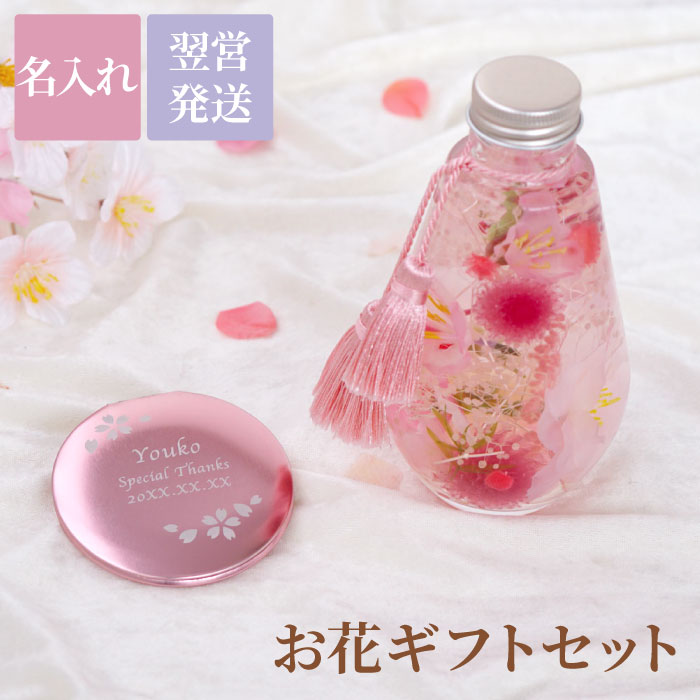 商品情報 【 桜ハーバリウム＆コンパクトミラーセット 】 ■桜ハーバリウム オイルの中でふわっと微笑む繊細で可憐なアーティフィシャル桜。 おうちでお花見気分を味わえる、春の瞬間をきゅんと閉じ込めたハーバリウムです♪ ■コンパクトミラー 華やかなお花のフレームと名入れで想い伝わる♪ さらにポーチ付きでギフトにぴったり◎ カラーは人気の3色をご用意しました♪ 渡す方に合わせてカラーをお選びいただけます！ コンパクトな手のひらサイズで薄型なので、 ポケットやポーチに入れてもかさばりません！ 鏡を見るのが楽しくなる、世界にひとつの贈り物です♪ 誕生日・開店祝い・長寿祝いなど、おめでとうの贈り物は 【コングラ】 にお任せ！ 仕様 / サイズ ［コンパクトミラー］ ■材質：アルミ ■サイズ：約70mm×67mm×6mm ■重量：約40g ■仕様：両面ミラー（片面拡大鏡） ［ポーチ］ ■材質：スエード調 ■サイズ：約90mm×120mm ［ハーバリウム］ ■素材：アーティフィシャルフラワー（造花）：桜、プリザーブドフラワー、ドライフラワー ■容器：ガラス製 ■サイズ：約φ72mm×高さ135mm ■重量：約430g 配送方法 宅配便／メール便不可 彫刻内容 ■文字数 【ローマ字】 1行目：7文字まで 2行目：15文字まで 3行目：15文字まで 【日本語】 1行目：5文字まで 2行目：10文字まで 3行目：10文字まで ※1行目：○○○／2行目：○○○／3行目：○○○と、それぞれご指示ください ※彫刻内容は 買い物かご→購入手続き→【備考欄】へ 特記事項 ［ハーバリウム］ ・植物は自然素材の為、大きさや形などに違いがあります ・植物の配置は一つ一つ異なるので見え方に違いがあります ・火気の近くや直射日光のあたる場所でのご使用はお避け下さい ・食用ではないので口に含まないようにしてください おすすめ！ 桜満開ハーバリウム ハーバリウムペン♪ 縁起物八角ミラー当店をよくご利用いただくシーン 長寿祝い 還暦 (かんれき) 60歳 / 古希 (こき) 70歳 / 喜寿 (きじゅ) 77歳 傘寿 (さんじゅ) 80歳 / 米寿 (べいじゅ) 88歳 / 卒寿 (そつじゅ) 90歳 白寿 (はくじゅ) 99歳 / 百寿 (ももじゅ) 100歳 / 茶寿 (ちゃじゅ) 108歳 皇寿 (こうじゅ) 111歳 / 大還暦 (だいかんれき) 120歳 結婚記念日 紙婚式 1周年 / 藁婚式 綿婚式 2周年 / 革婚式 3周年 / 花婚式 4周年 木婚式 5周年 / 鉄婚式 6周年 / 銅婚式 7周年 / ゴム婚式 8周年 / 陶器婚式 9周年 錫婚式 アルミ婚式 10周年 / 鋼鉄婚式 11周年 絹婚式 亜麻婚式 12周年 / レース婚式 13周年 / 象牙婚式 14周年 水晶婚式 15周年 / 磁器婚式 20周年 / 銀婚式 25周年 / 真珠婚式 30周年 珊瑚婚式 翡翠婚式 35周年 / ルビ−婚式 40周年 / サファイア婚式 45周年 金婚式 50周年 / エメラルド婚式 55周年 / ダイヤモンド婚式 60周年 プラチナ婚式 75周年 お祝いごと プレゼント / Present / ギフト / Gift / 贈り物 / 贈りもの / 贈物 / 贈呈品 / 贈呈 贈答品 / 贈答 / ラッピング / ギフトセット / セット / 誕生日 / 誕生日プレゼント 出産祝い / 出産内祝い / 内祝い / 結婚 / 結婚式 / 結婚祝い / 結婚内祝い / 結婚記念 引き出物 / 引出物 / 開店祝い / 開店 / 周年記念 / 周年祝い / 地鎮祭 / 成人 成人祝い / 成人式 / 新成人 / 卒業 / 卒業祝い / 入学祝い / 就職祝い / 新入社員 新生活 / 新生活応援 / 初任給 / 記念日 / 記念品 / 昇進 / 転勤 / 送別 / 退官 / 定年 退職 / 送別品 / 勤続 / 永年勤続 / 勤続記念 / 永年表彰 / 祝い 季節のイベント お正月 / 新年会 / バレンタイン / バレンタインデー / バレンタインデイ / Valentine ホワイトデー / ホワイトデイ / whiteday / 母の日 / Mother's Day / 父の日 Father's Day / こどもの日 / 子供の日 / 子どもの日 / 端午の節句 / お中元 / 敬老の日 敬老 / 勤労感謝 / クリスマス / Xmas / Christmas / Chrismas / くりすます 忘年会 / お歳暮 / 増税 / 令和 / 令和元年 / 2019 / 2020 プレゼントのお相手 男性 / メンズ / Men's / めんず / 女性 / レディース / れでぃーす / レディス レデイース / Ladies / 父 / お父さん / おとうさん / 義父 / お義父さん / 義理の父 義理父 / 義理 / パパ / Papa / 母 / お母さん / 母さん / おかあさん / ママ / まま お義母さん / 義理の母 / 義理母 / 義母 / Mama / 子供 / 子ども / こども / キッズ Kids / 男の子 / 女の子 / おじいちゃん / じい / お爺ちゃん / お祖父ちゃん / 祖父 おばあちゃん / ばあ / ちゃん / お婆ちゃん / お祖母ちゃん / 祖母 / 妻 / 夫 / 彼氏 彼女 / 友達 / 上司 / 部下 / 先輩 / 後輩 / 孫 / まご / マゴ / 夫婦 / めおと / 両親 カップル / 10代 / 20代 / 30代 / 40代 / 50代 / 60代 / 70代 / 80代 名入れ表記について お客様ごとに、 名入れ / 名いれ / ないれ / 名前 / 名前入 / 名前入り / 名前入れ / 彫刻 / 刻印 / 文字入れ / ネーム入れ といったように表現が異なりますが、当店では全てを総称して「 名入 れ 」と表記しております。 ※ 名 前 入 り と表記している商品も一部御座います。