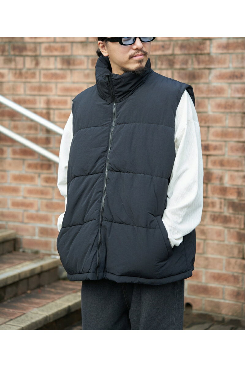 どんな装いにもマッチするシンプルな中綿ベスト。ボリュームがありながらも軽い着心地がうれしい一着です。【素材】表地には丈夫なナイロン生地を使用。【デザイン】スタンドネックで首まわりもあたたかく、裾はドロスト仕様で絞ることが可能です。ゆったり身幅でレイヤードもしやすいのが特徴。【おすすめコーディネート】スウェットやニットはもちろん、ロックTやネルシャツなどを合わせたアメカジスタイルもおすすめです。★Instagramにて近日発売予定のアイテムやルックをご紹介しております。　＠vence_sharestyle［モデルサイズ］　171cm［着用サイズ］　Lサイズ[サイズ情報]■M着丈:74/バスト:136/肩幅:50■L着丈:77/バスト:142/肩幅:52■LL(XL)着丈:80/バスト:146/肩幅:53[商品コード] 35100058[素材] 表地 ナイロン100% 裏地 ポリエステル100% 中綿 ポリエステル100%[洗濯表示] 手洗い可、ドライクリーニング可（F)、ウェットクリーニング（W)[原産国] 中国軽くあたたか！着回しもバッチリな中綿ベスト ナイロン中綿ベスト どんな装いにもマッチするシンプルな中綿ベスト。ボリュームがありながらも軽い着心地がうれしい一着です。【素材】表地には丈夫なナイロン生地を使用。【デザイン】スタンドネックで首まわりもあたたかく、裾はドロスト仕様で絞ることが可能です。ゆったり身幅でレイヤードもしやすいのが特徴。【おすすめコーディネート】スウェットやニットはもちろん、ロックTやネルシャツなどを合わせたアメカジスタイルもおすすめです。★Instagramにて近日発売予定のアイテムやルックをご紹介しております。　＠vence_sharestyle